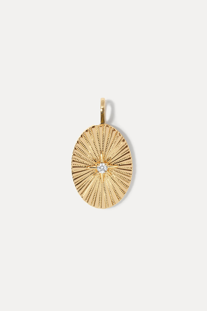 Gold oval Amanda Charm with a sunburst starburst pattern and a sparkling center stone on a white background.