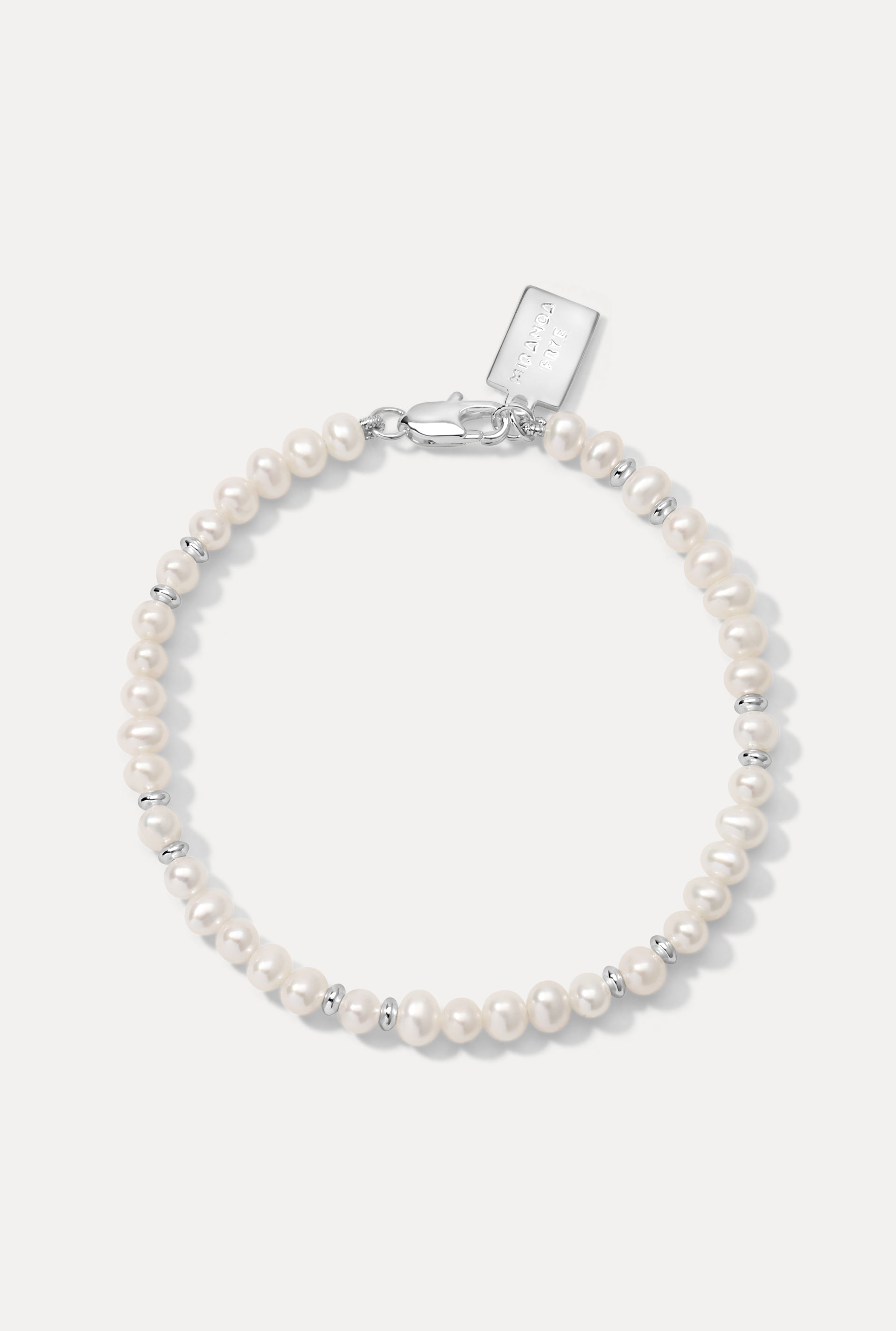 Silver Bette Bracelet with pearls and silver beads laid flat on a white background.