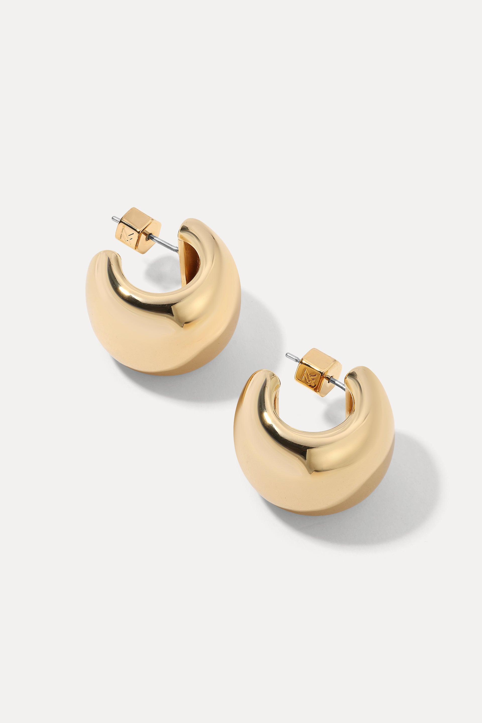 Gold thick-tapered Camilla hoop earrings on a plain white background.