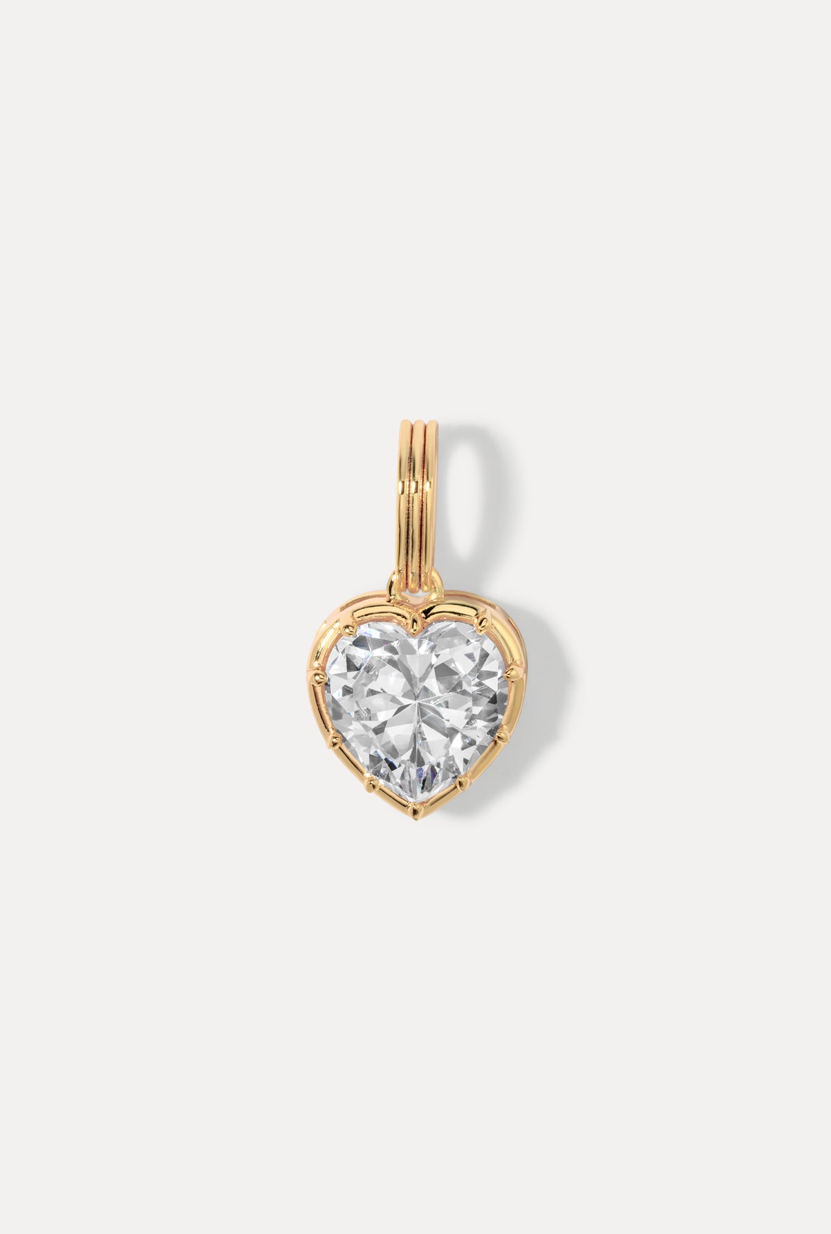 Gold Cheri Charm featuring a heart silhouette with a faceted cubic zirconia on a white background.
