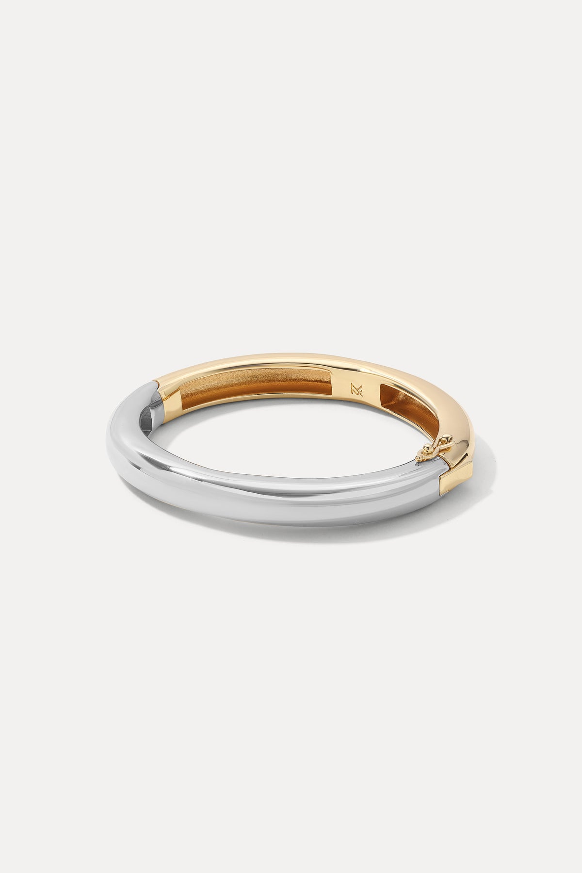 Mixed metal Cleo Cuff in gold and silver laid flat on a white background.