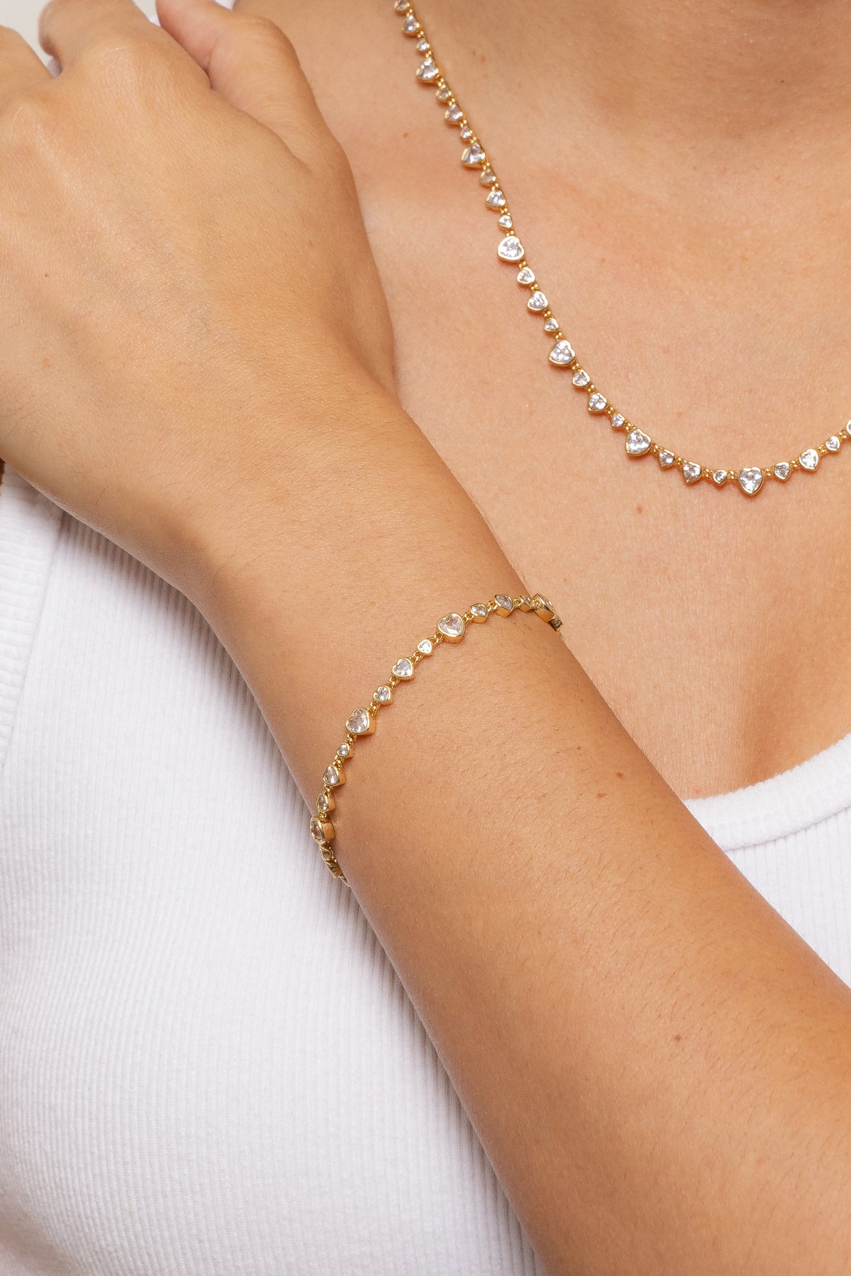 Close-up model image of the gold Cora bracelet and necklace.