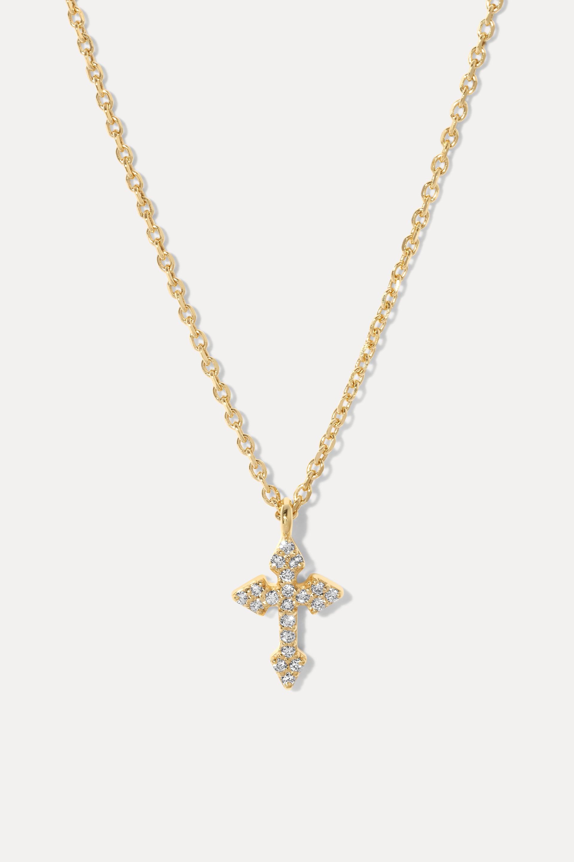 Diamond Cross Necklace is a 14K gold cable chain necklace with a cross pendant adorned with small clear stones.