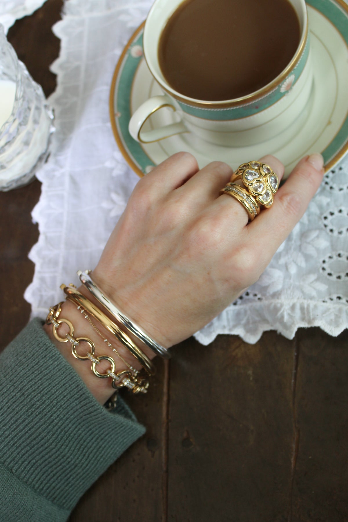 Model wearing the gold aria bracelet and mina cuffs in gold and silver paired with the bardot and Ariana Ring in gold.