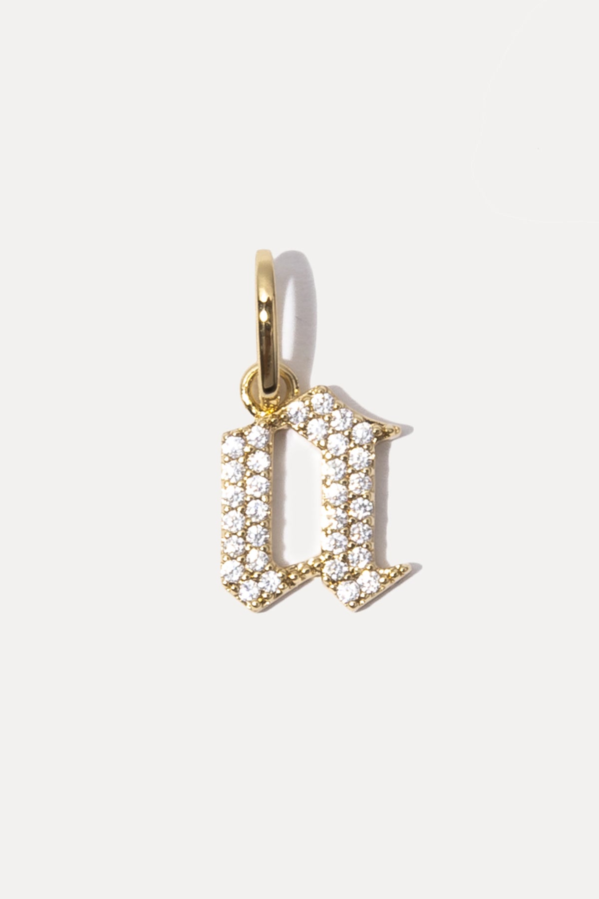 Gold Gothic Letter A charm with pavé cubic zirconia on a white background.