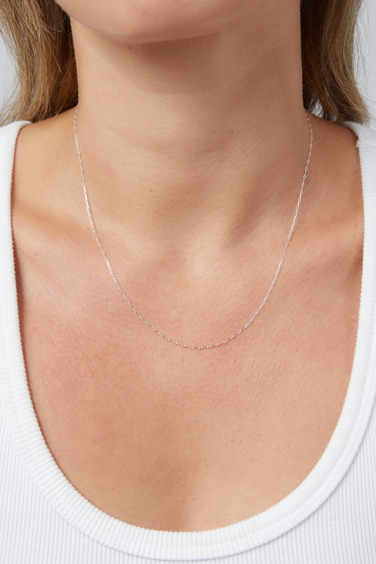 Close-up of a model wearing the silver Jade Chain link necklace near her collarbone.