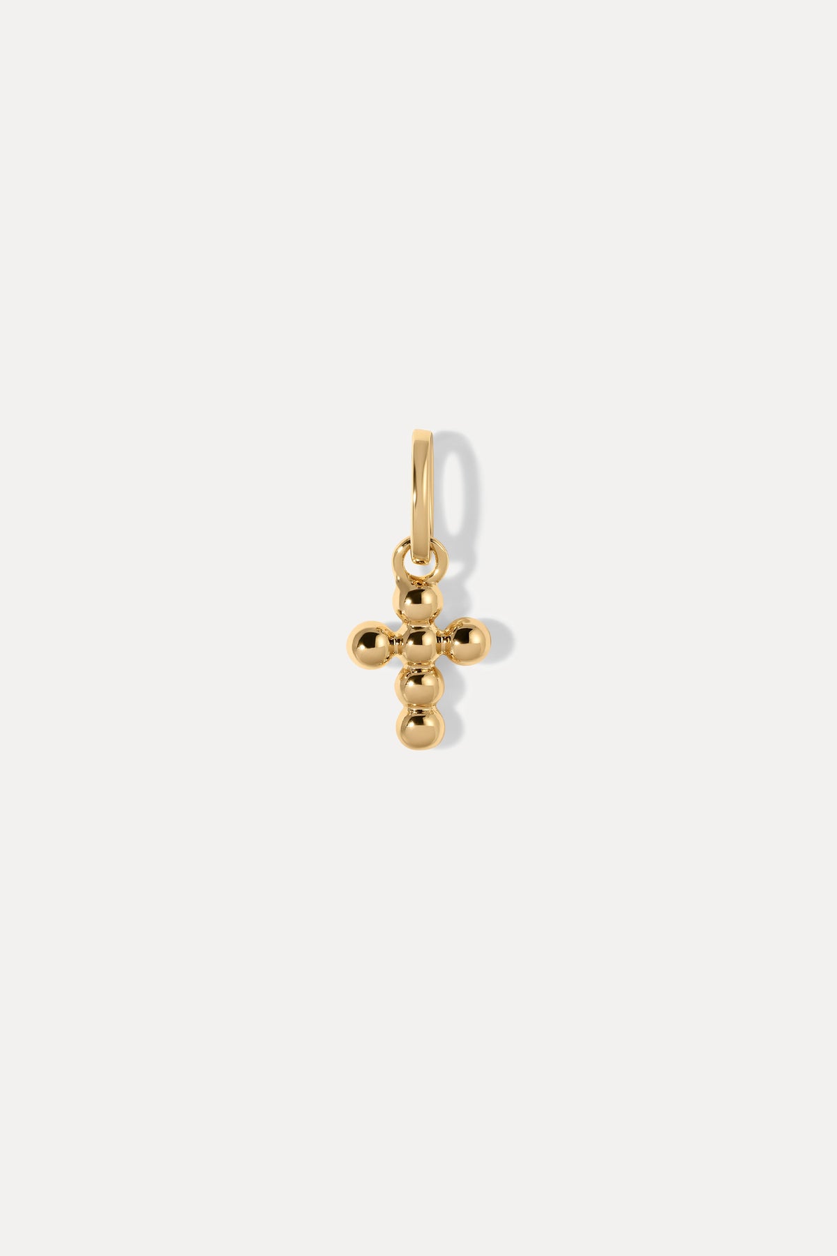 Gold beaded cross charm on a bail against a plain white background.