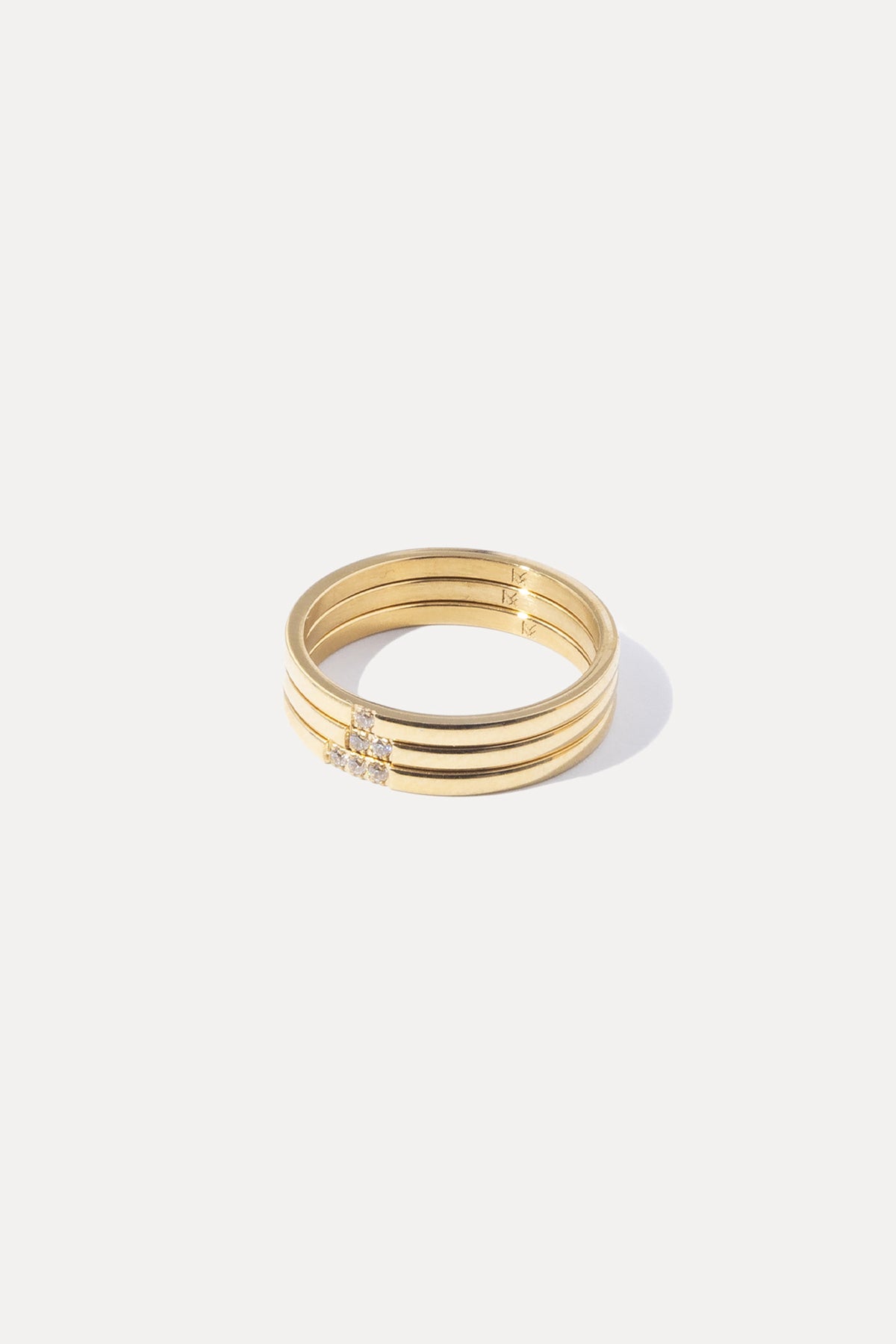 Set of three gold Leah stacking rings with subtle crystal accents, centered on a plain white background.