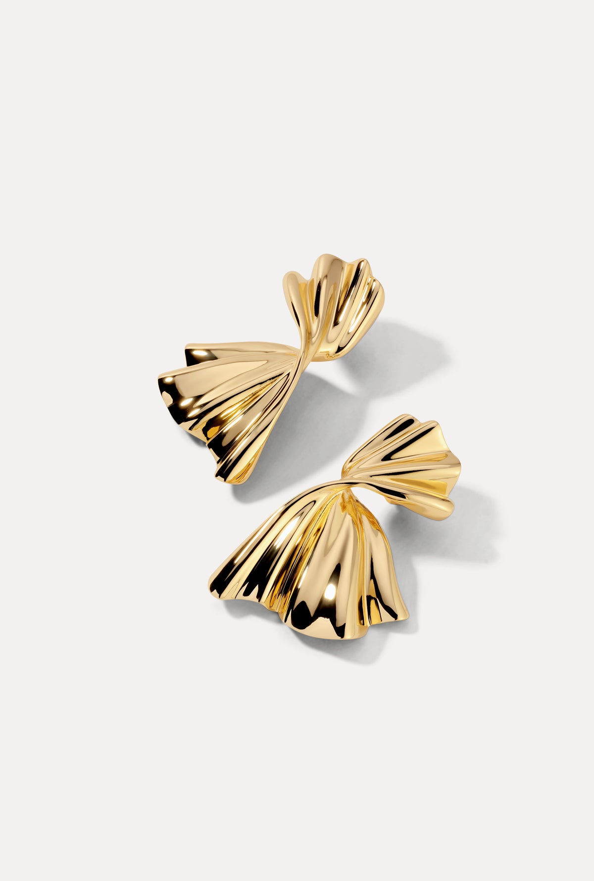 Gold Monica earrings flat lay on white background showing fan silhouette.