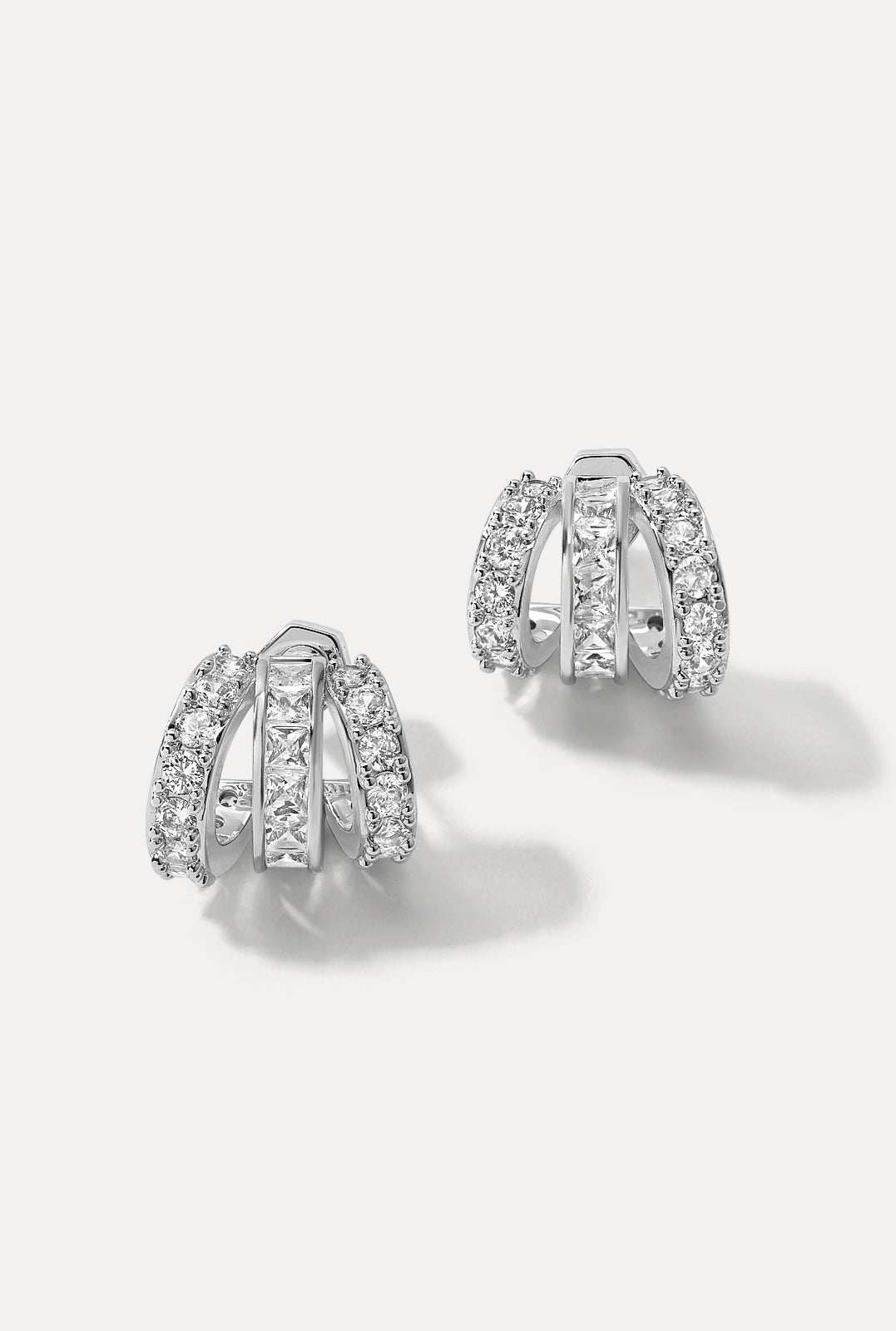 Pair of silver Sabrina Huggies on a white background showing triple band CZ details.