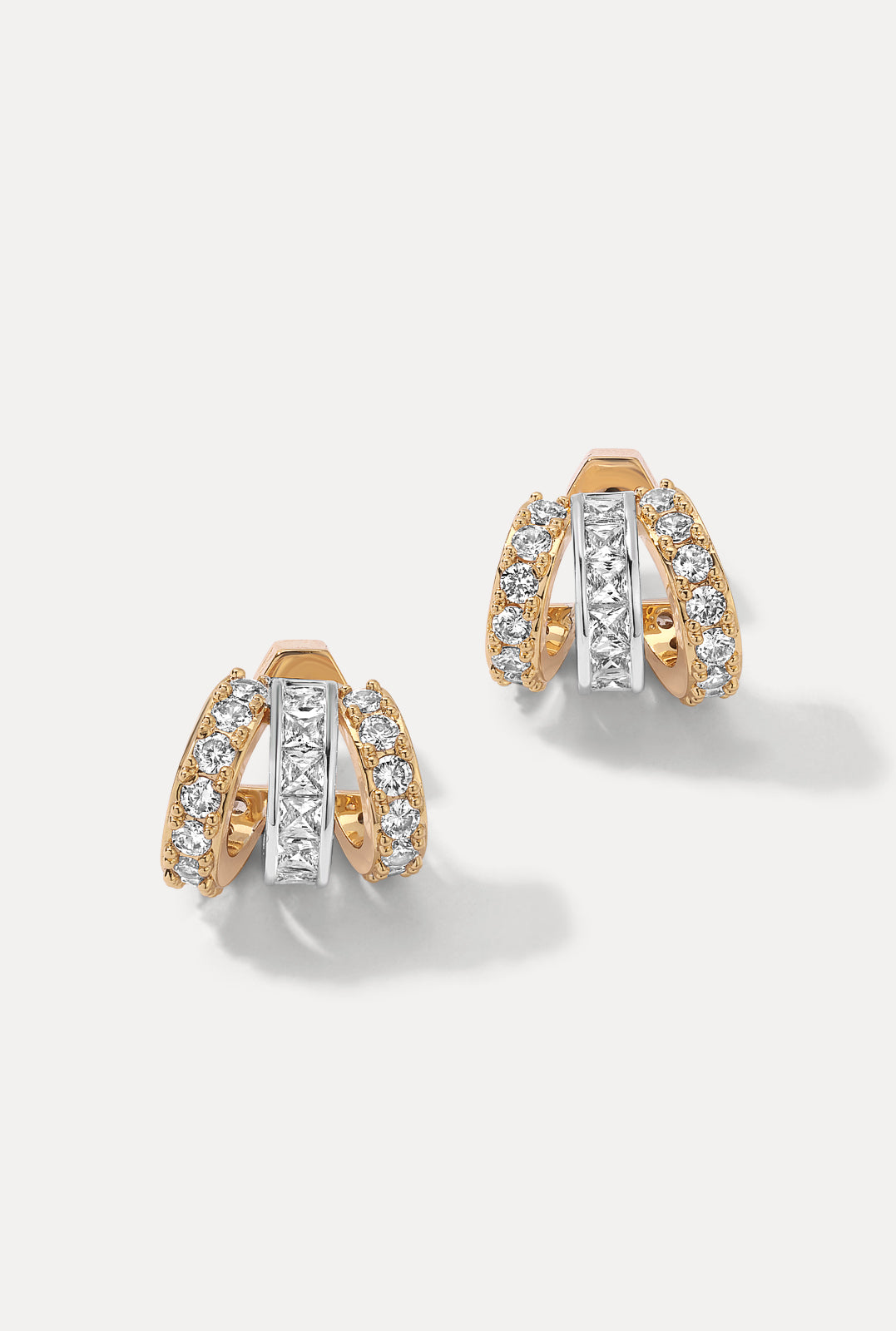 Pair of gold Sabrina Huggies on a white background showing triple-band look with CZ accents.