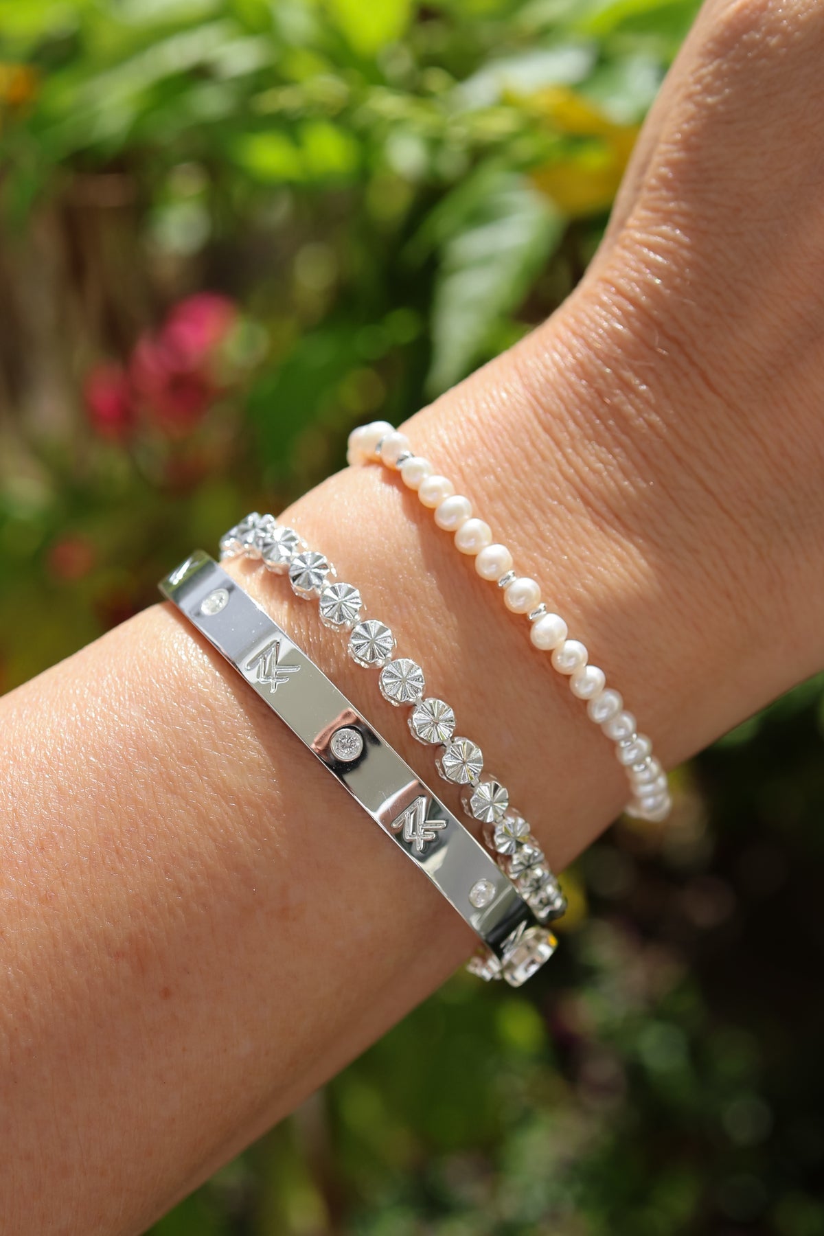 Model wearing the bette bracelet in silver paired with the silver Essie bracelet and MF cuff.