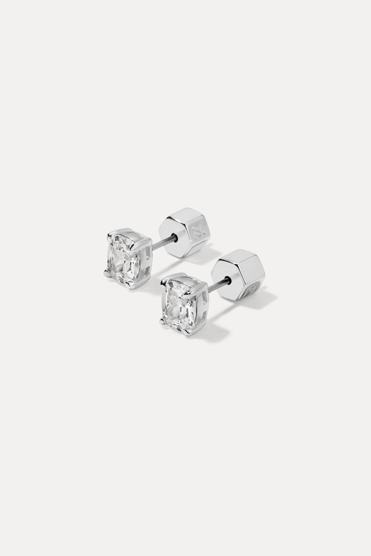 Pair of silver Sophia Studs with cushion-cut cubic zirconia stones flat lay on a white background.