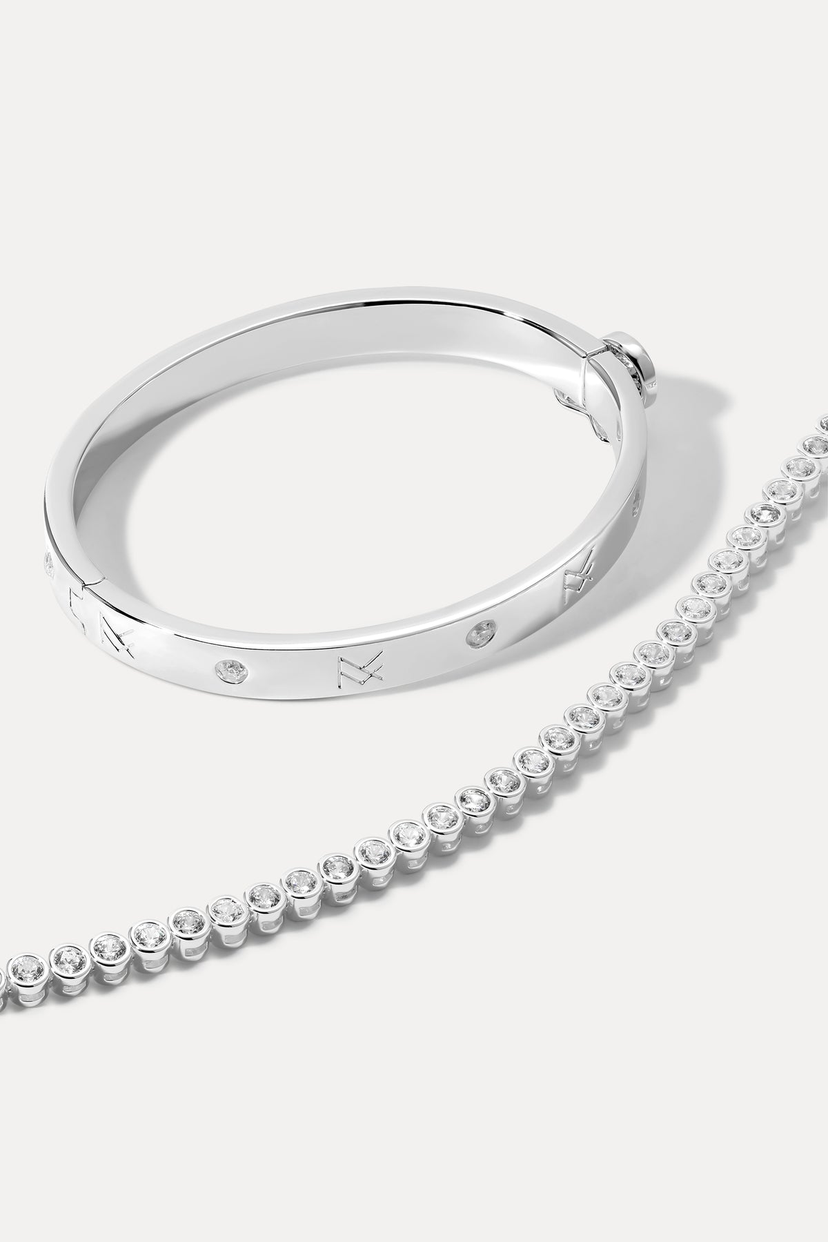 Silver layered bracelet stack displayed on a plain white background.