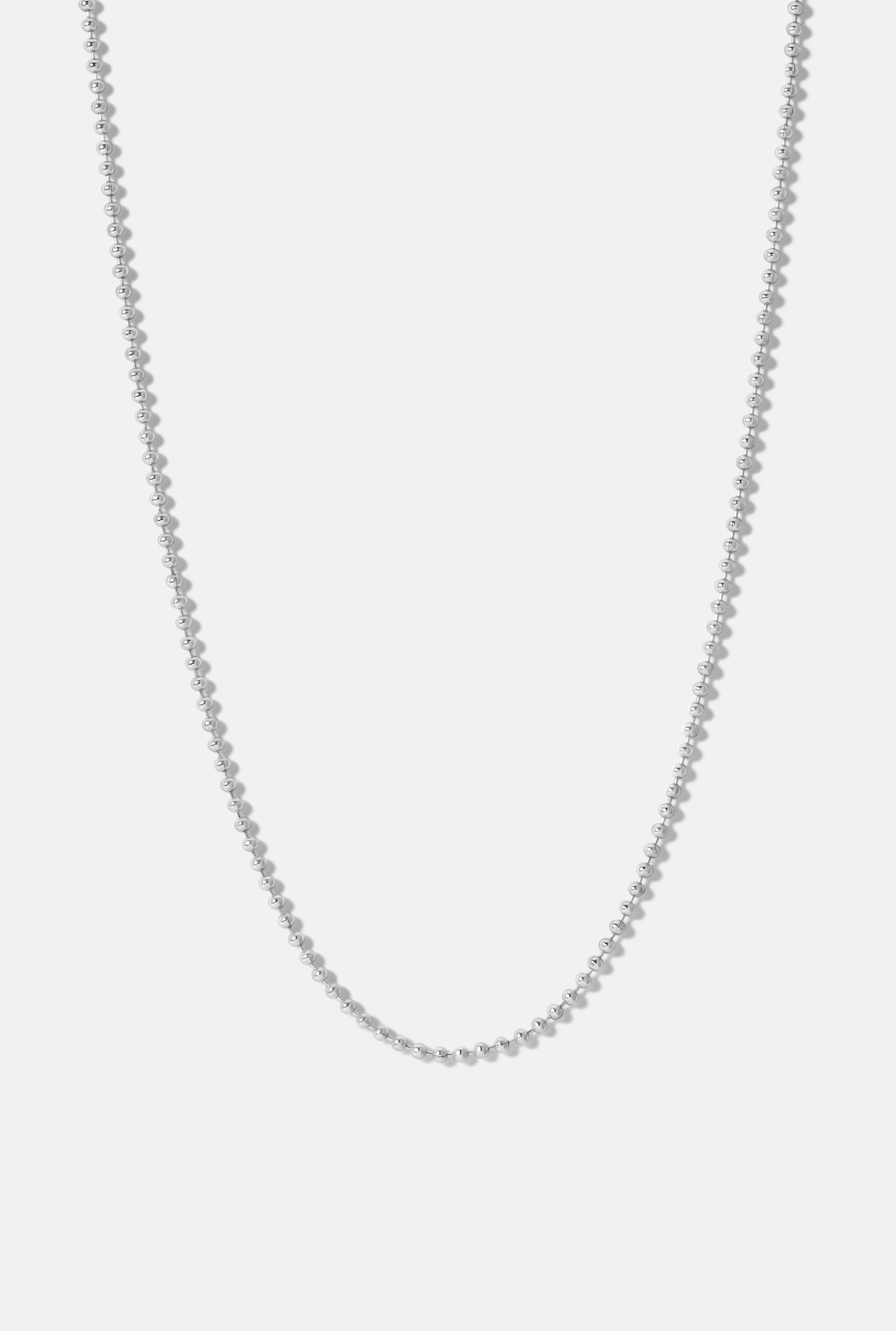 Long silver Whitney continuous ball chain necklace displayed in a U-shape on a white background.