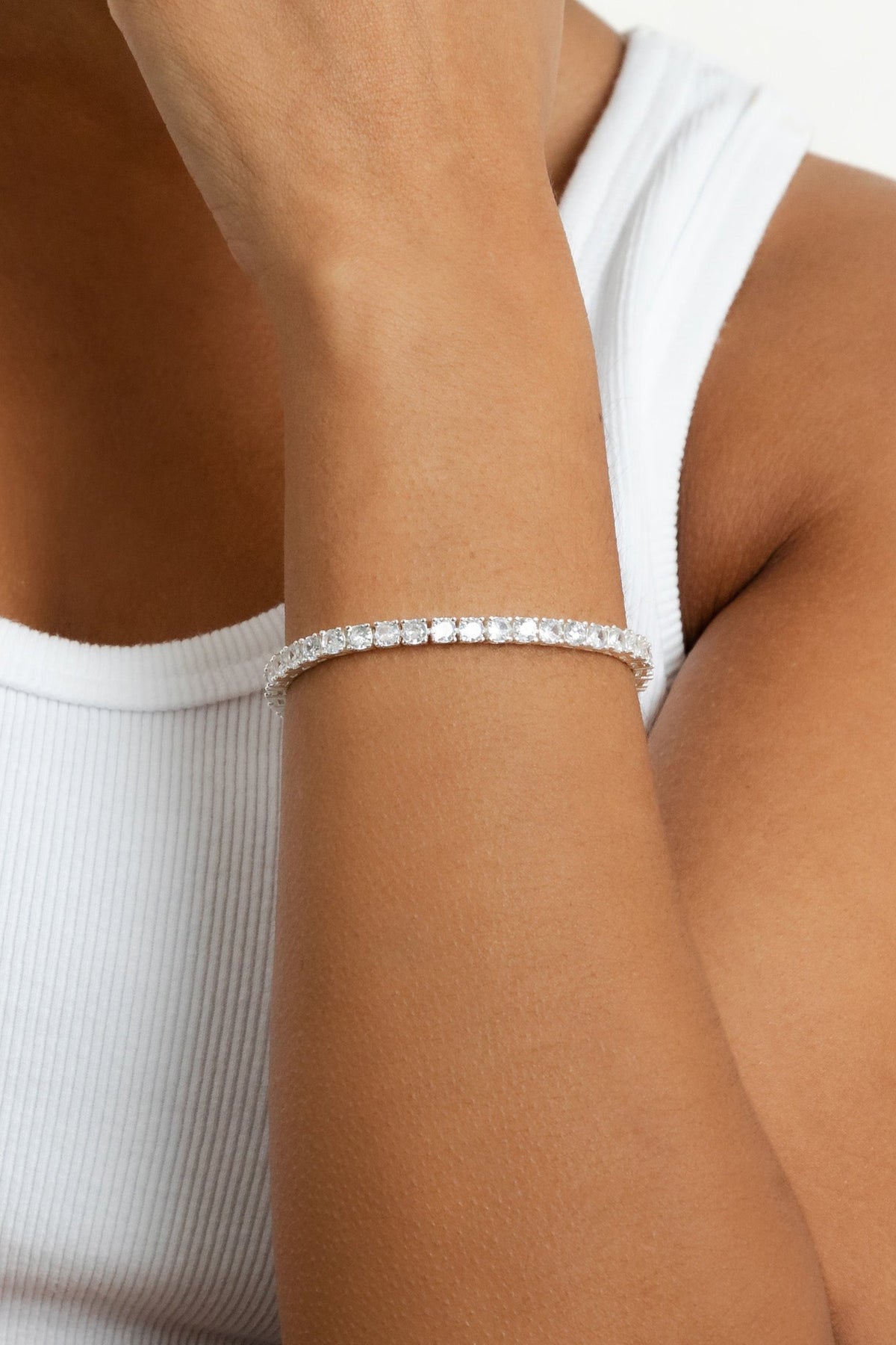 Close-up image of a model's wrist wearing the silver Audrey bracelet against a white tank top.