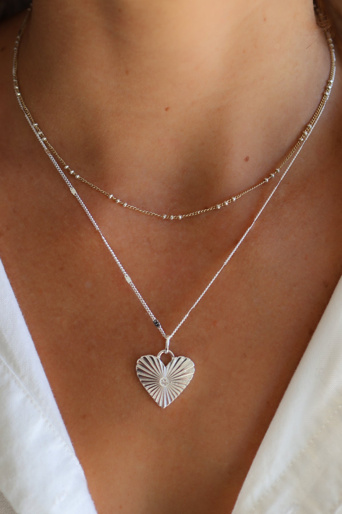 Model wearing the Coco chain in silver paired with the Eleanor charm and poppy chain.
