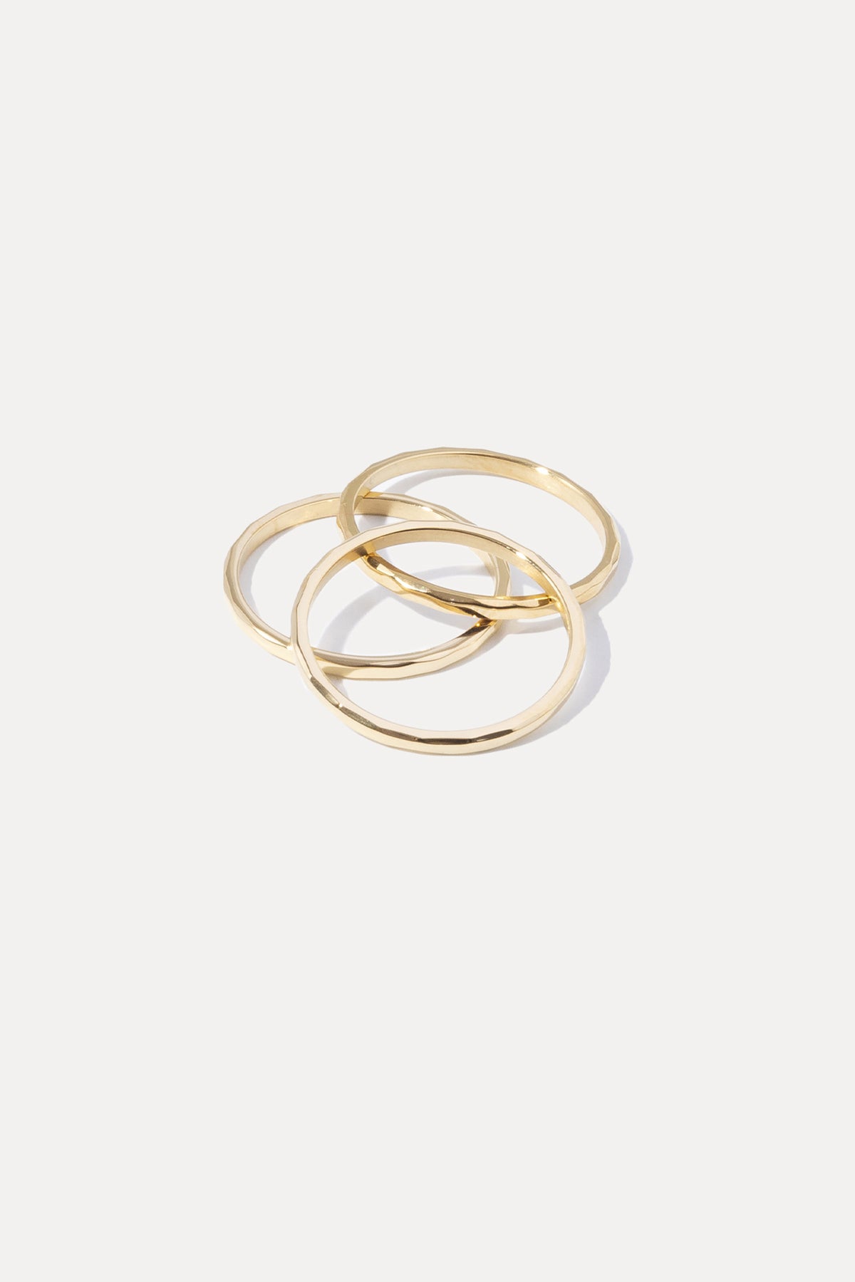 Gold Hazel Stacking Rings set featuring three slim hammered bands displayed on a white background.