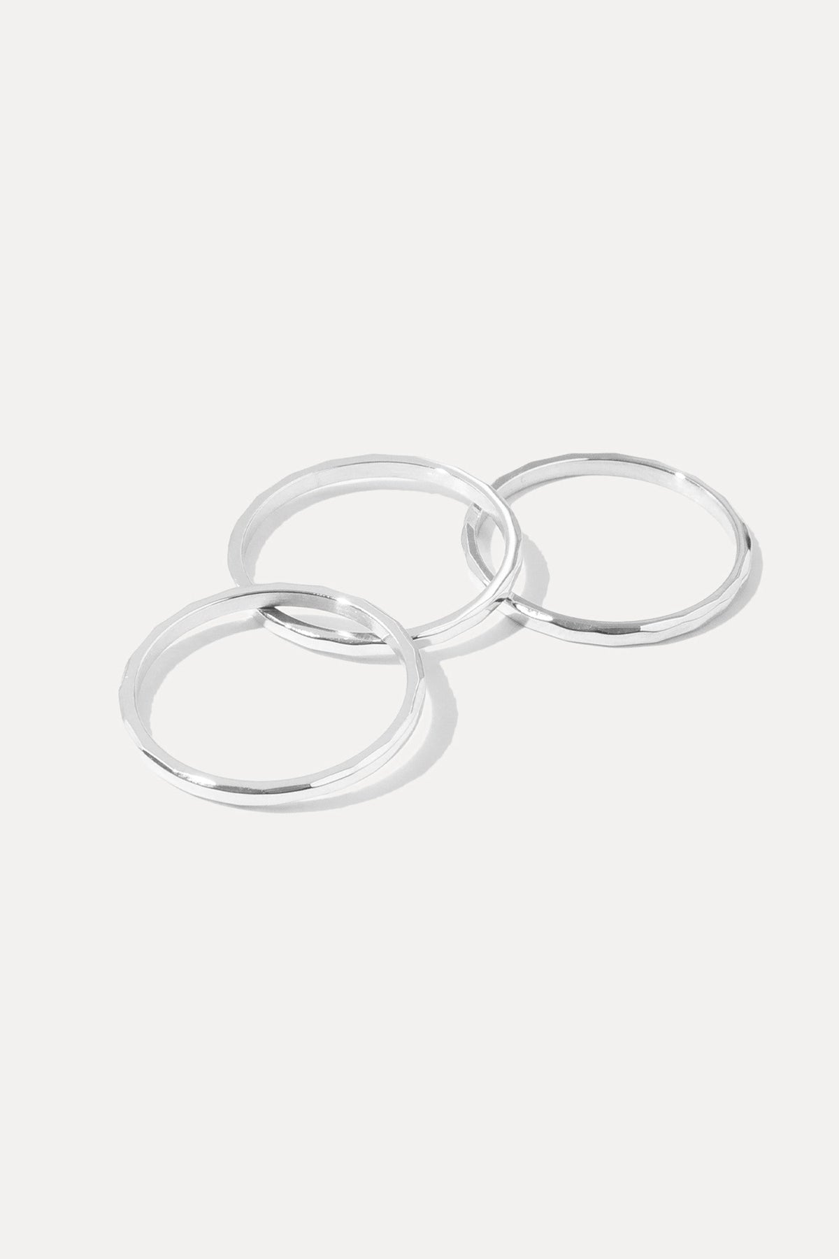 Silver Hazel Stacking Rings set featuring three slim hammered bands displayed on a white background.