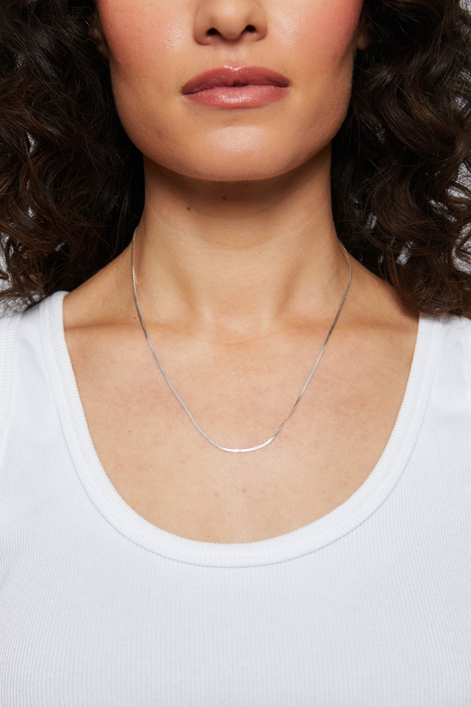 Close-up of a model wearing the silver Josephine herringbone Chain necklace near her collarbone.