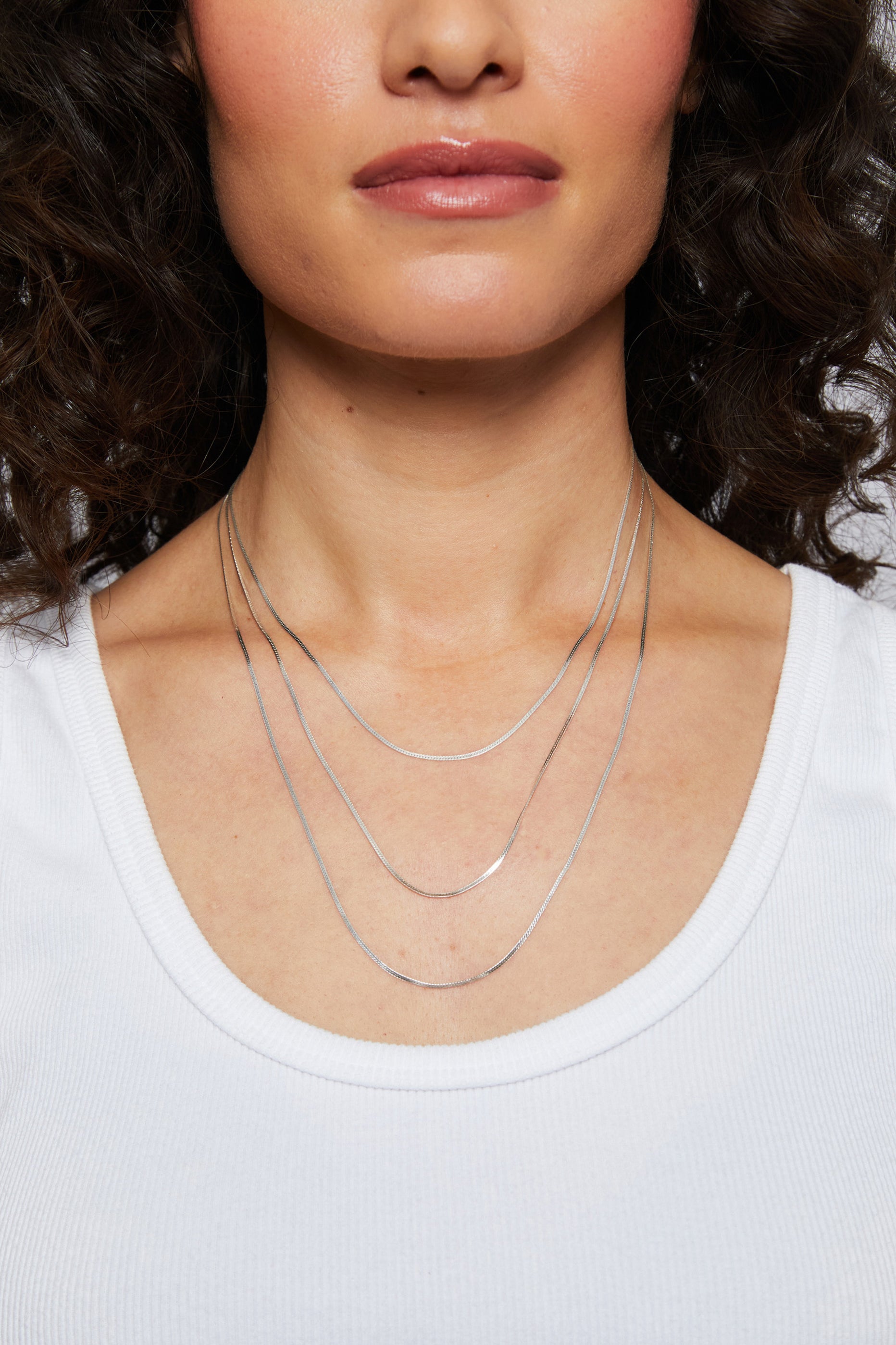 Model showcasing the silver Josephine chain in three distinct lengths.