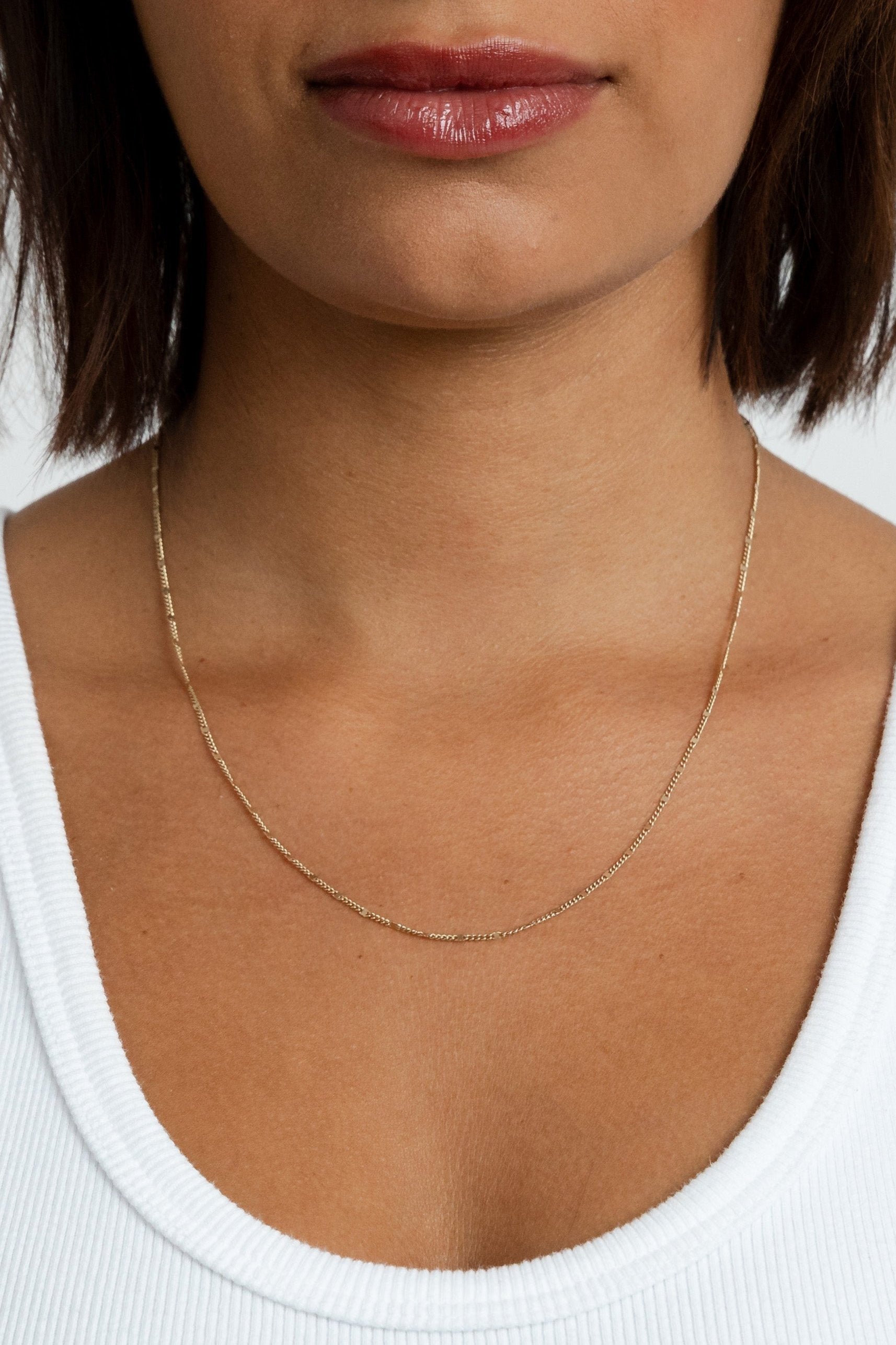 Model showcasing the gold filled Marlowe Chain necklace resting lower on her neckline.