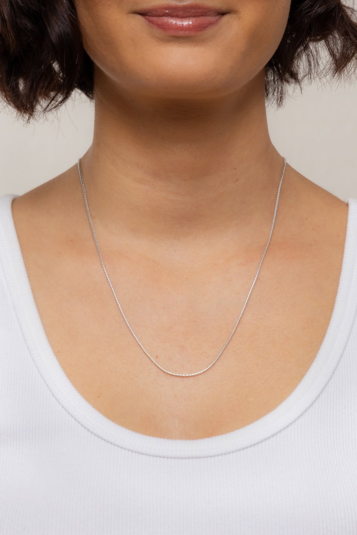 Model showcasing the sterling silver Mina Chain necklace resting lower on her neckline.