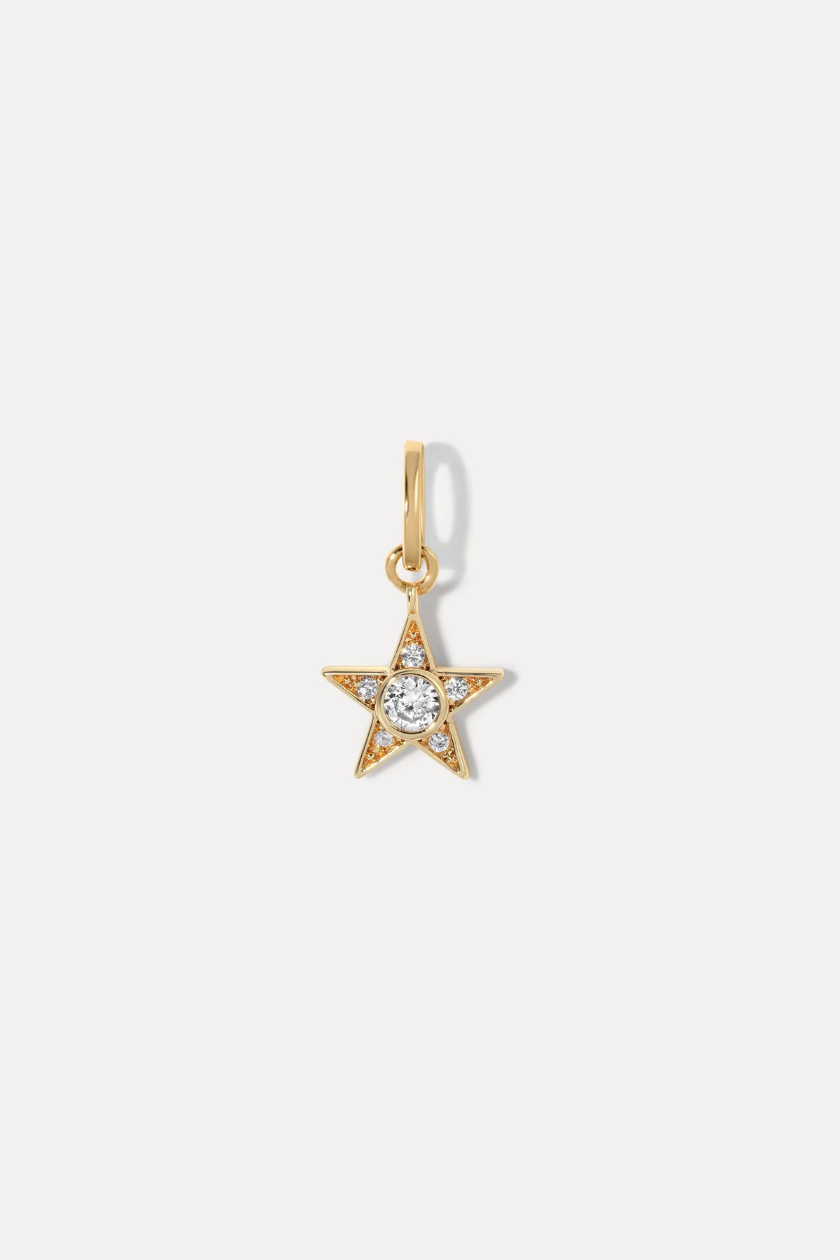 Gold star charm with a central sparkling stone set on a standard bail against a plain white background.