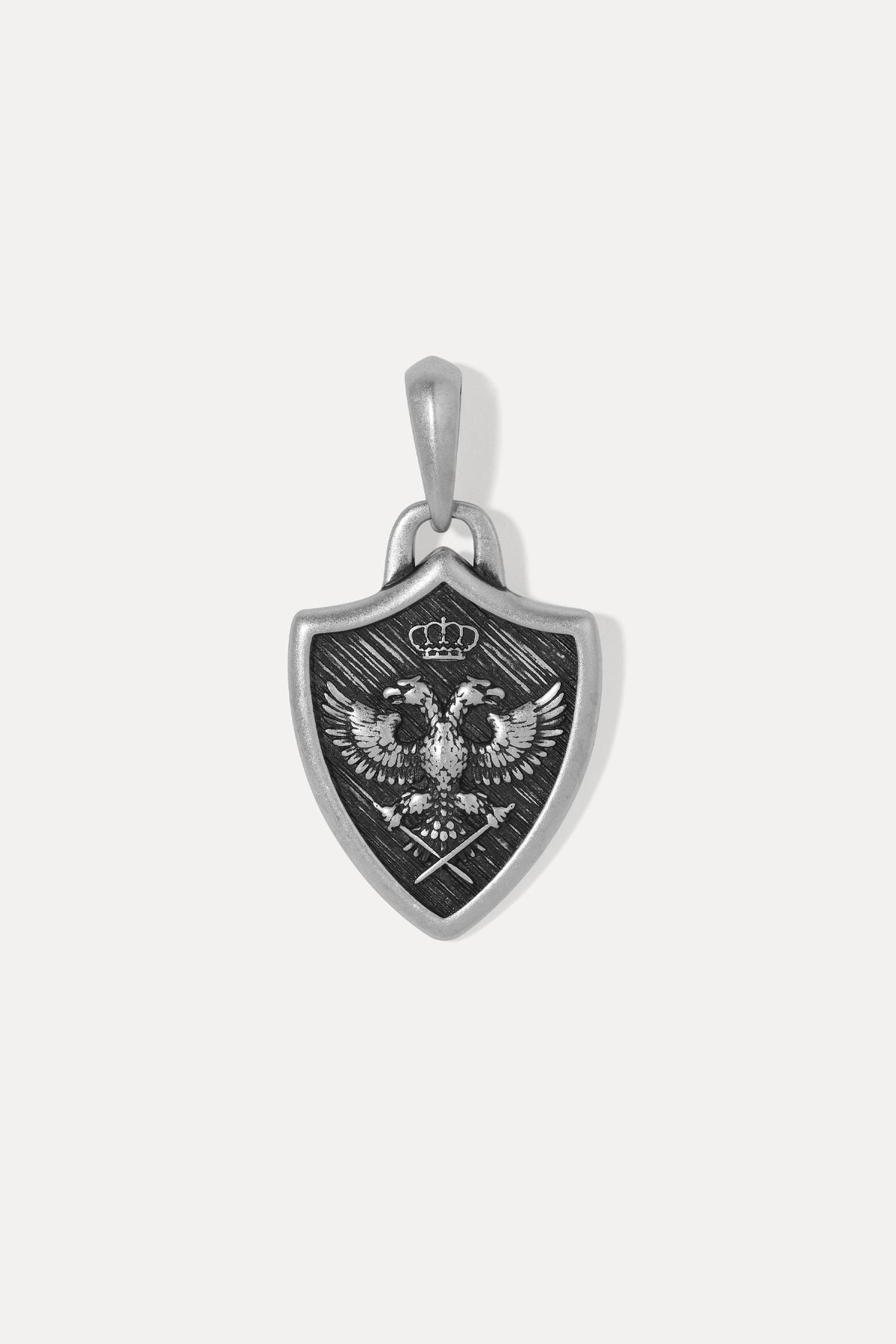 A silver shield-shaped pendant featuring an embossed double-headed eagle with a crown, displayed on a clean white background.