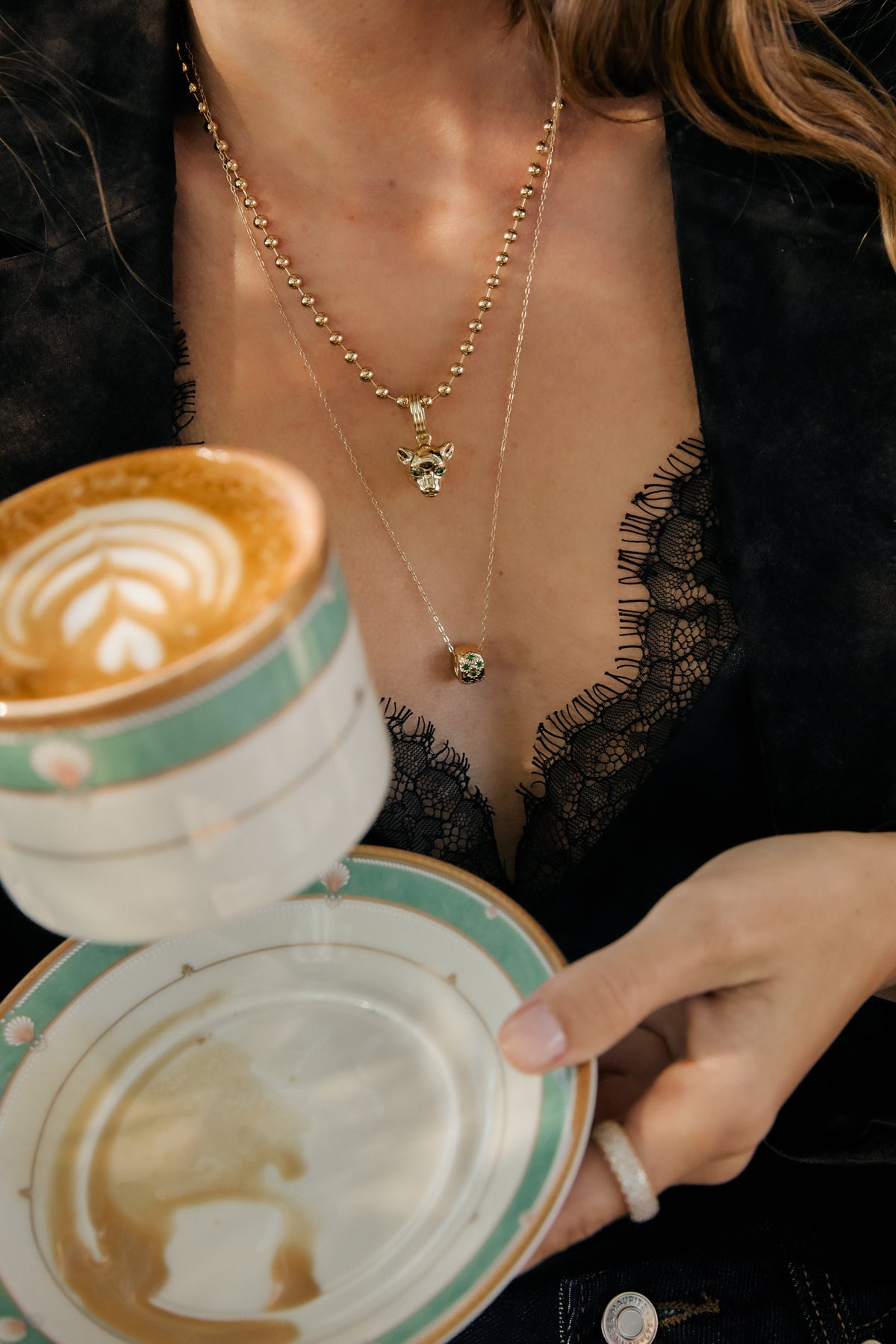 Model wearing gold Panther Charm,amelia necklace, Nora chain with emerald Celeste Slider, and Vivienne ring