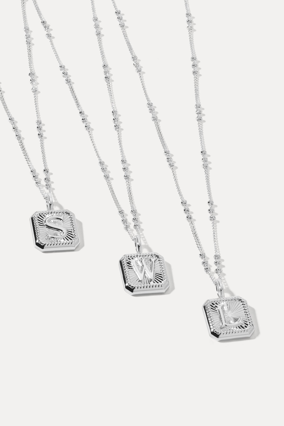 Silver initial letter pendant attached to a silver satellite chain displayed against a plain white background.