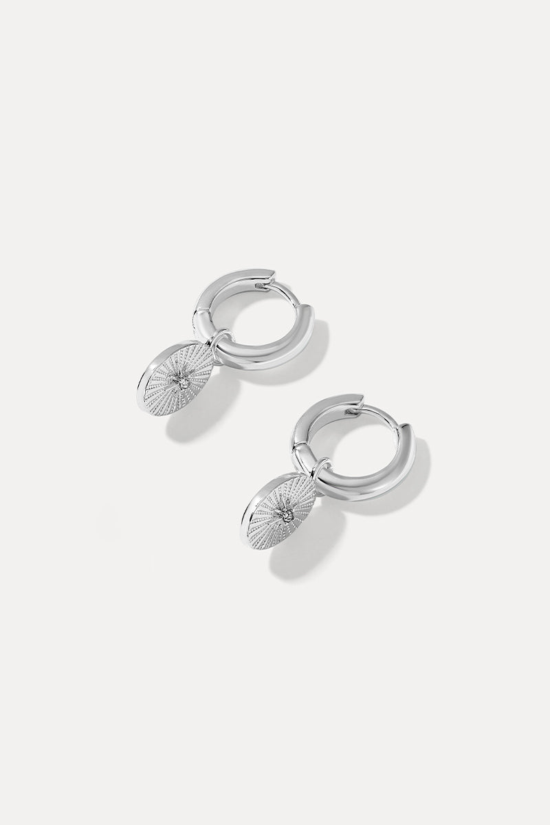 Pair of silver Amanda huggie earrings with starburst drops on a plain white background.