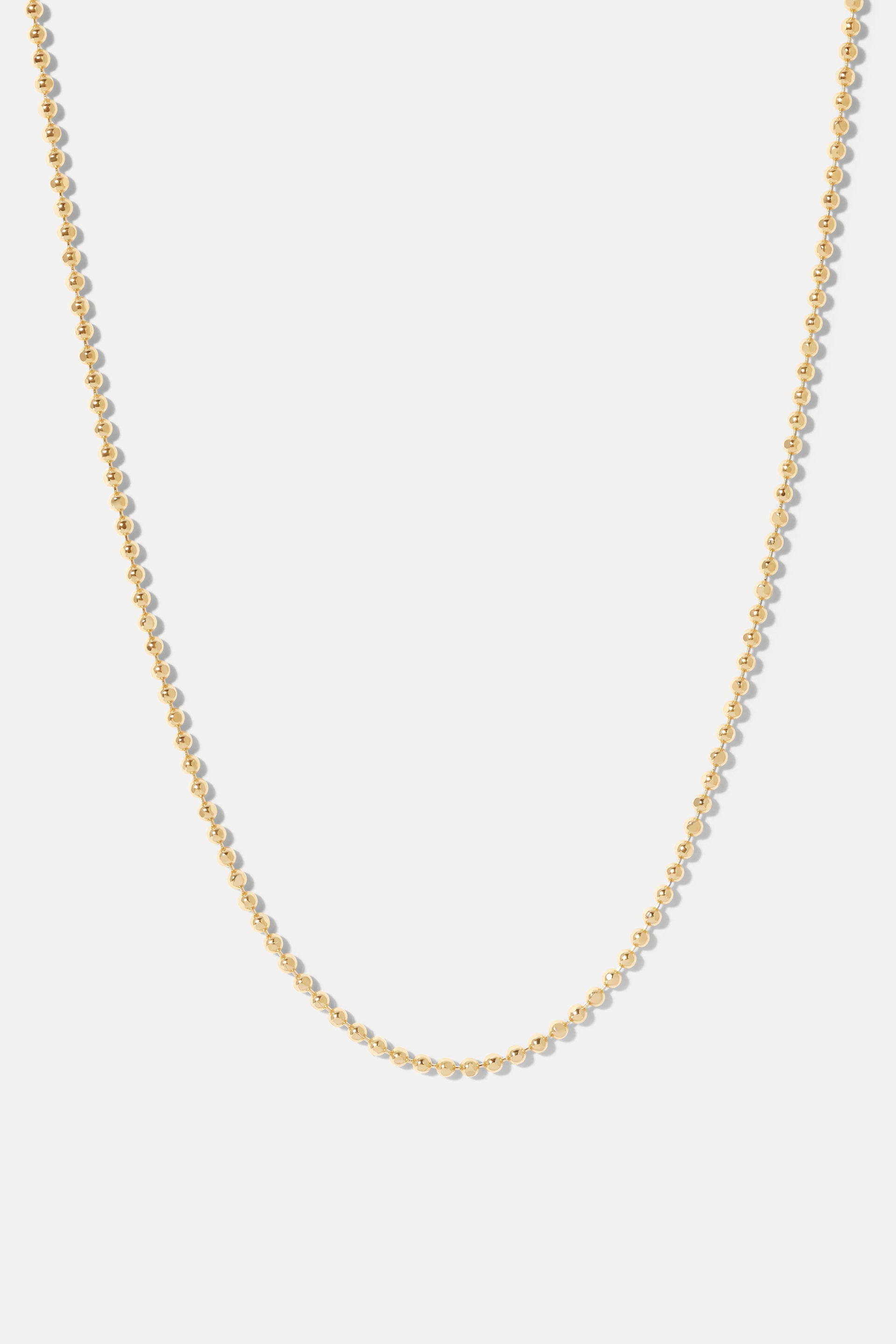 Gold Avery ball chain necklace displayed in a U-shape on a clean white background.
