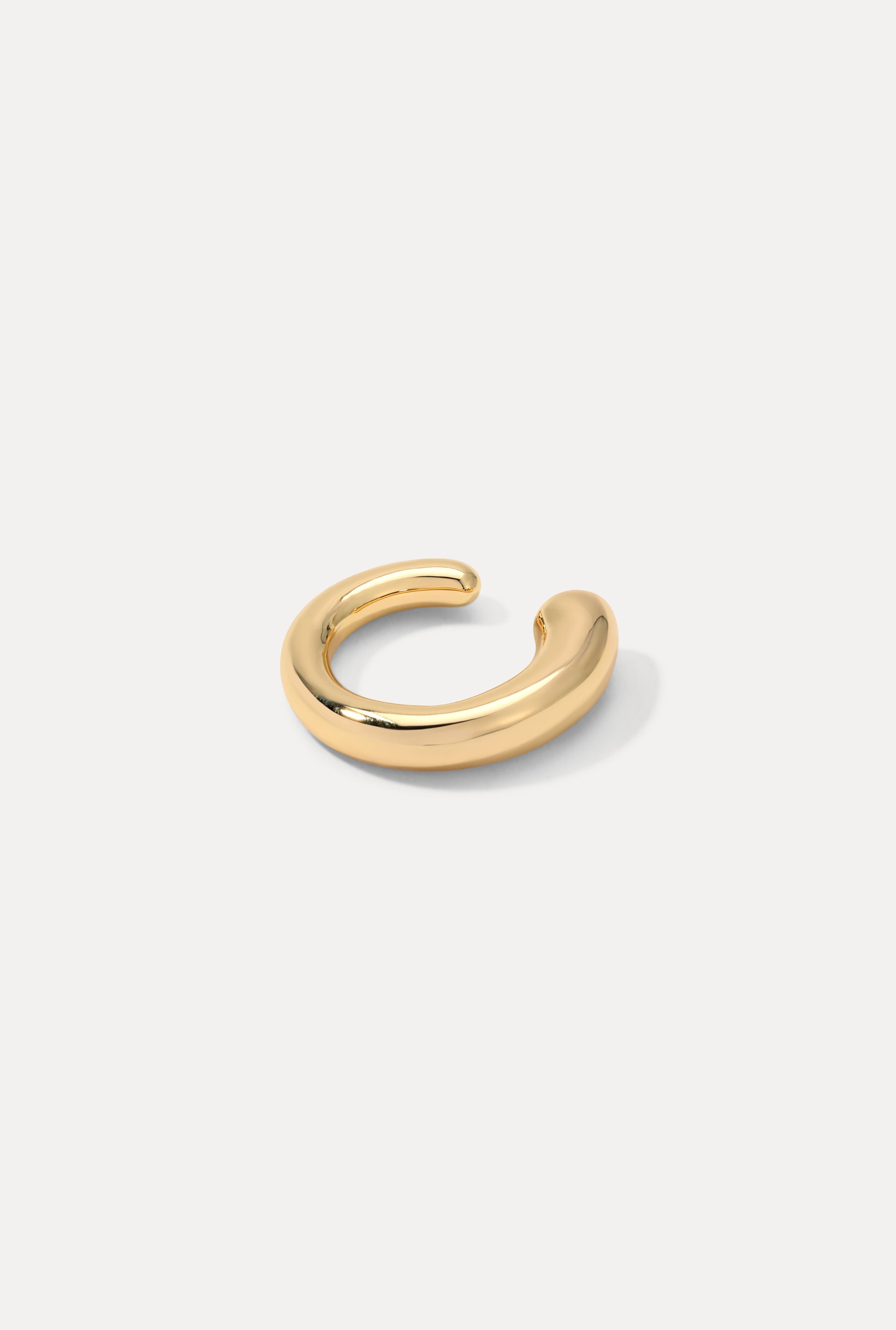 Gold Bella Ear Cuff with a smooth, thick curved silhouette on a plain white background.