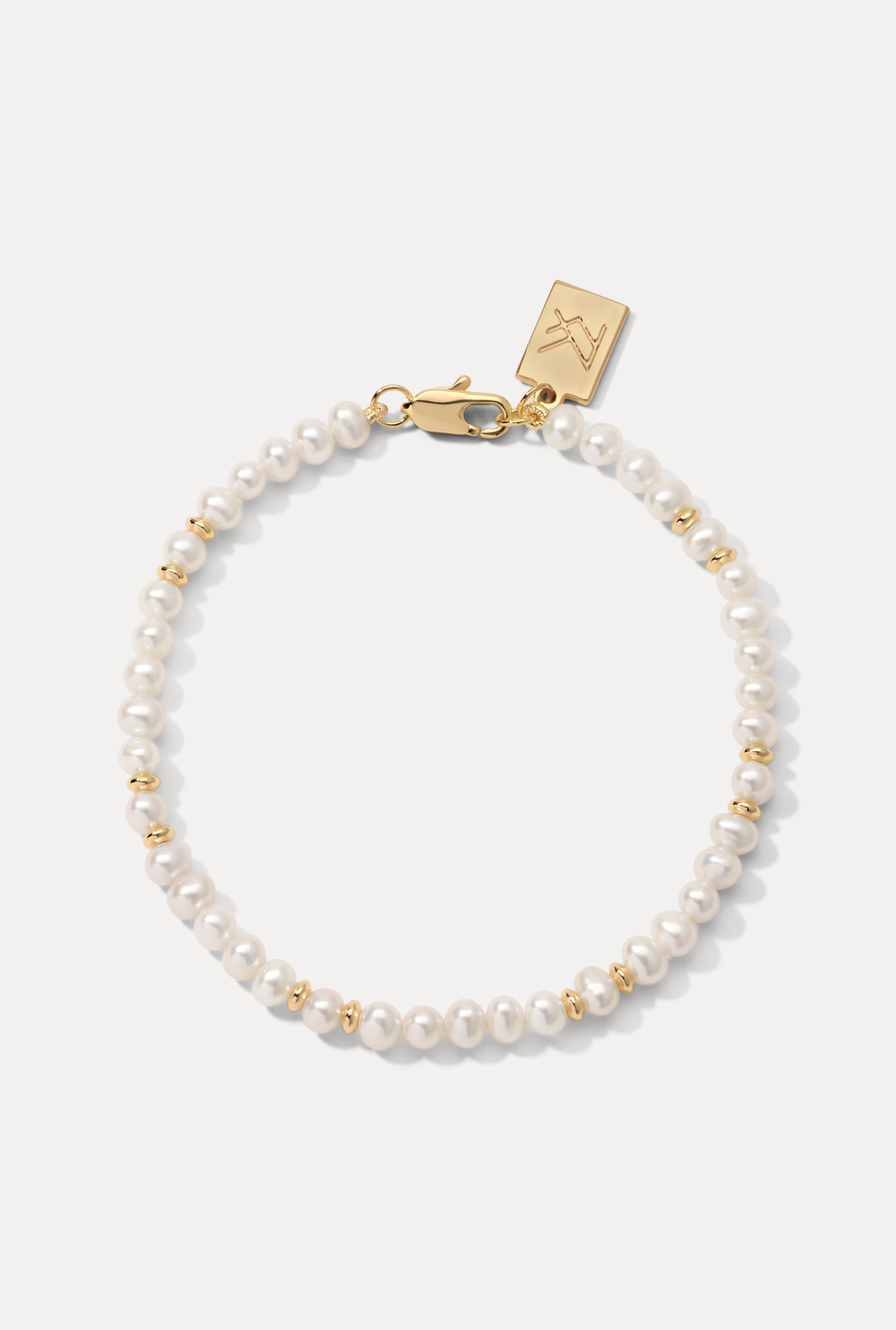 Gold Bette Bracelet featuring natural pearls and gold beads laid flat on a clean white background.