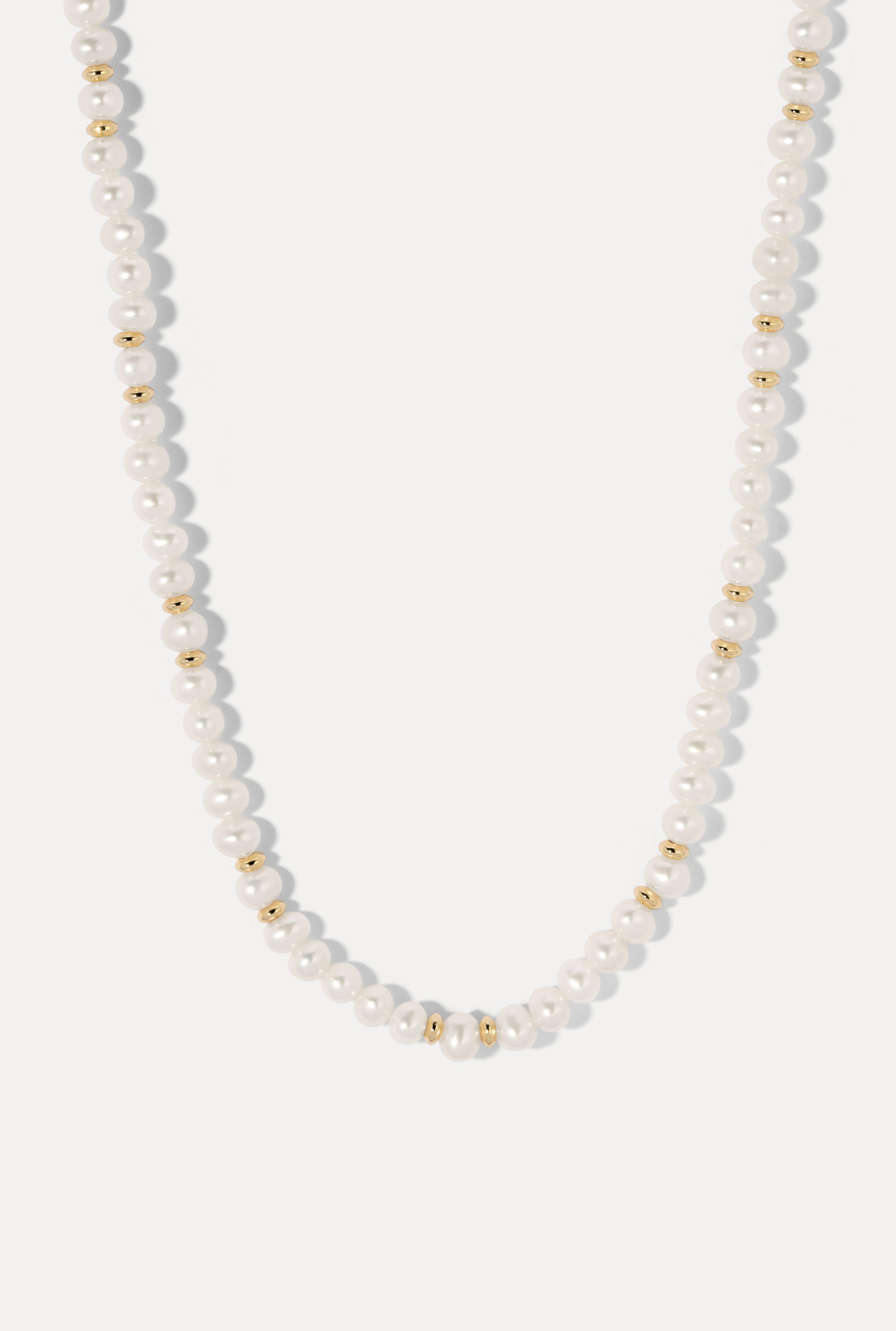 Bette Gold Pearl Necklace displayed in a U-shape loop on a plain white background.
