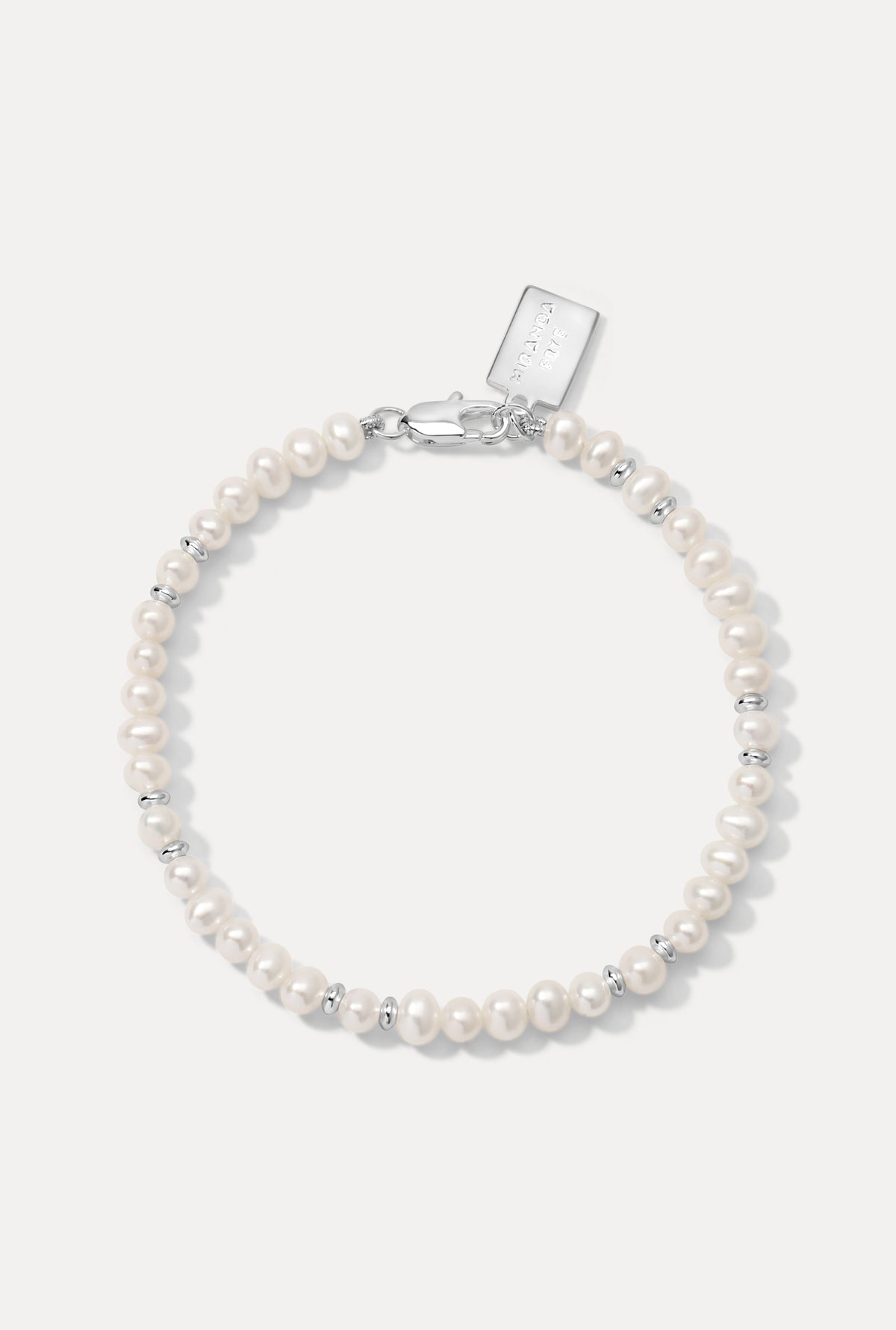 Silver Bette Bracelet with pearls and silver beads laid flat on a white background.