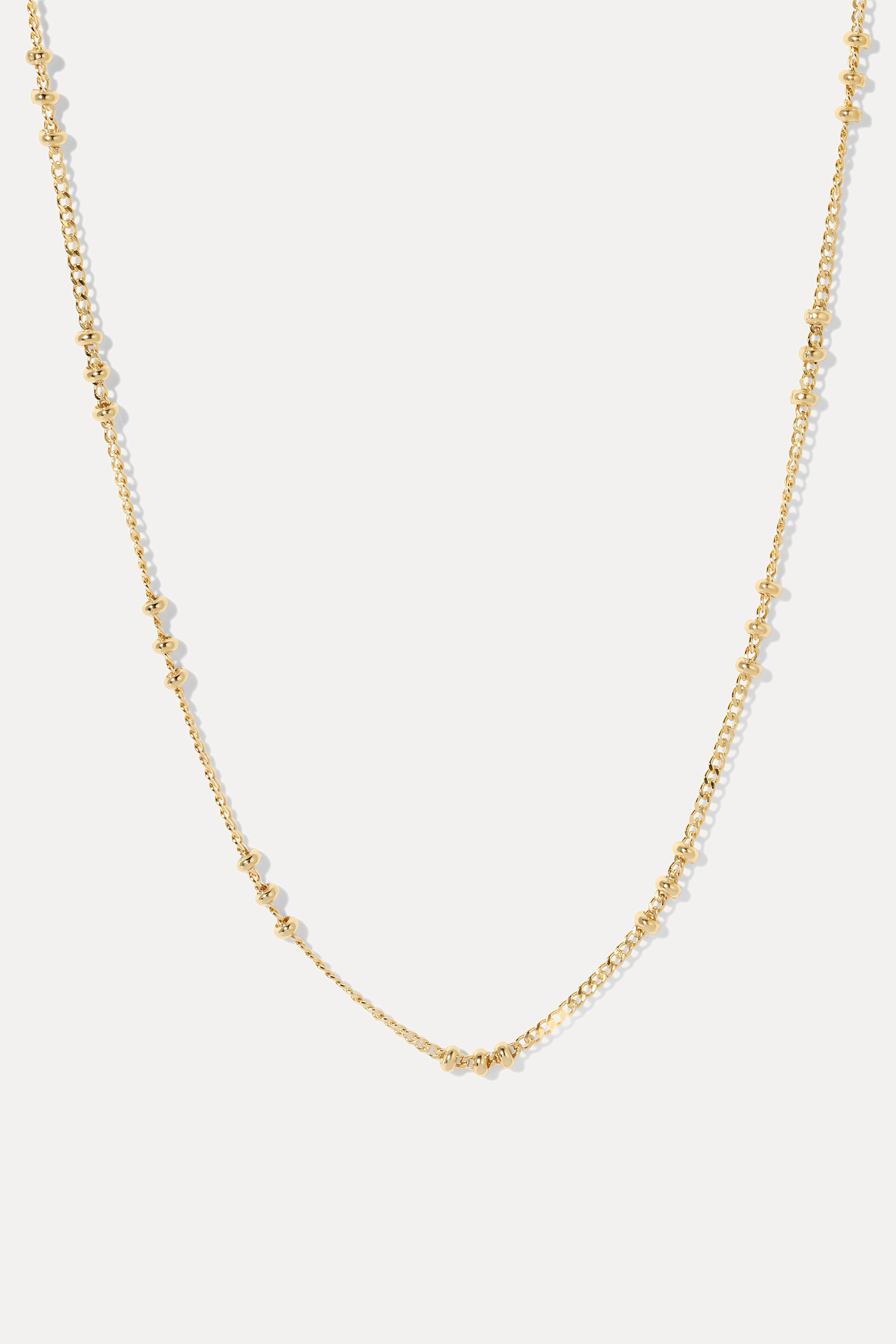 Gold Brinley satellite chain necklace displayed in a U-shape on a clean white background.