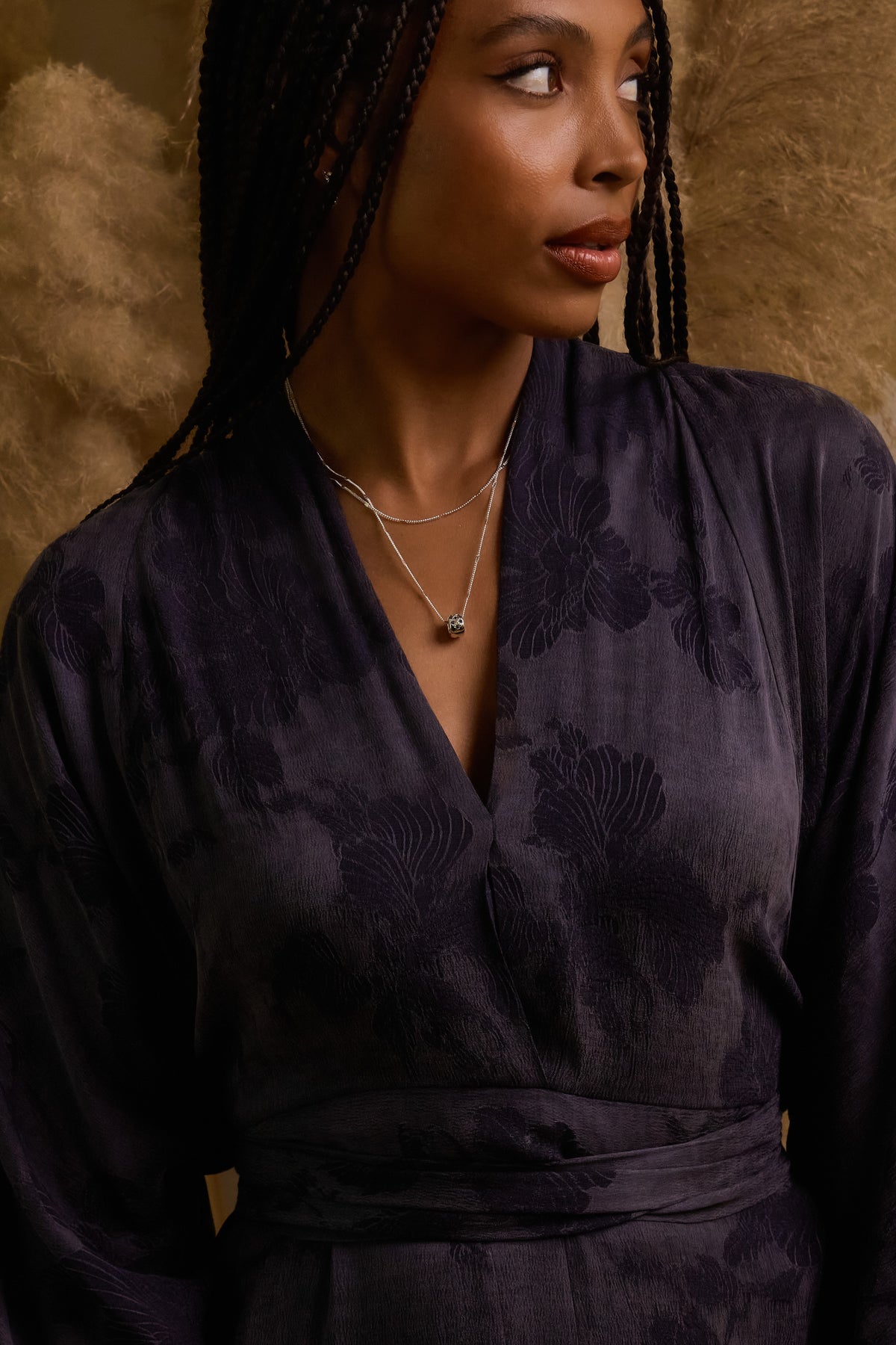 Model wearing silver Celeste Slider charm layered on silver coco chains, styled in a dark floral jacquard wrap top.