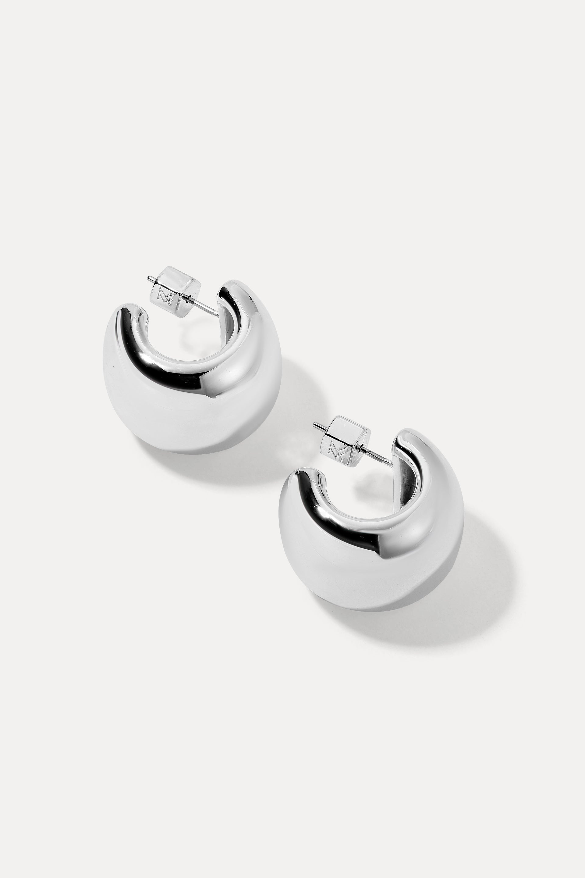 Image of the Silver thick-tapered Camilla hoop earrings on a white background.
