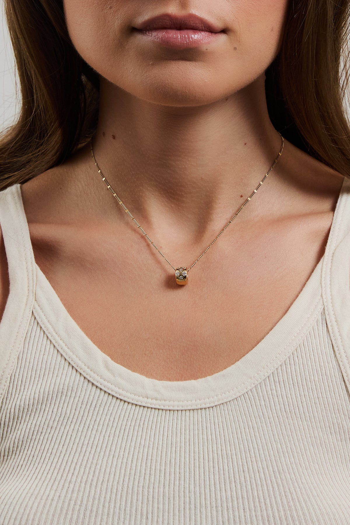 Model wearing gold filled marlowe chain and gold clear stone celeste slider charm