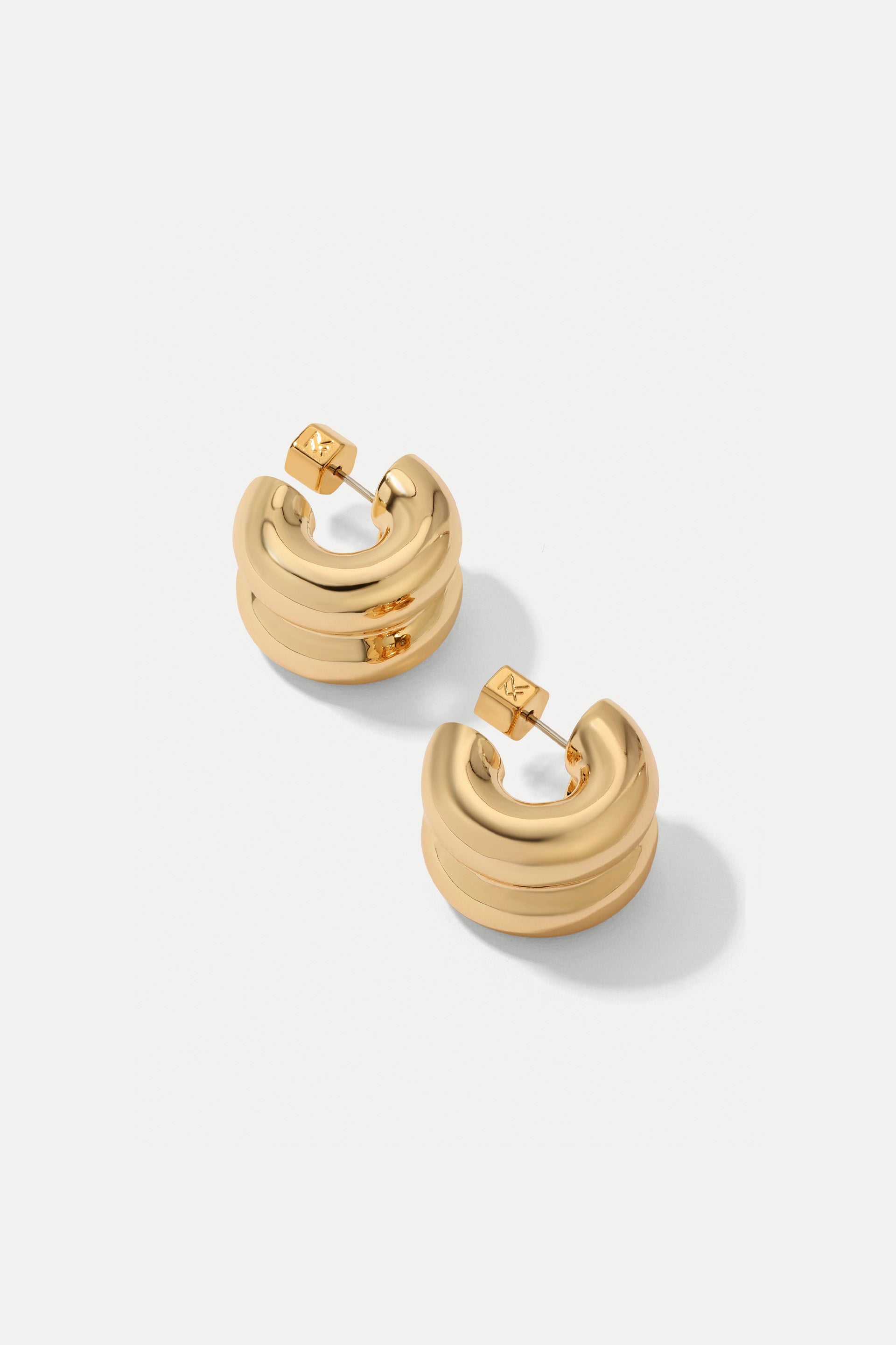 Gold double-layered Chloe huggie hoop earrings displayed on a clean white background.
