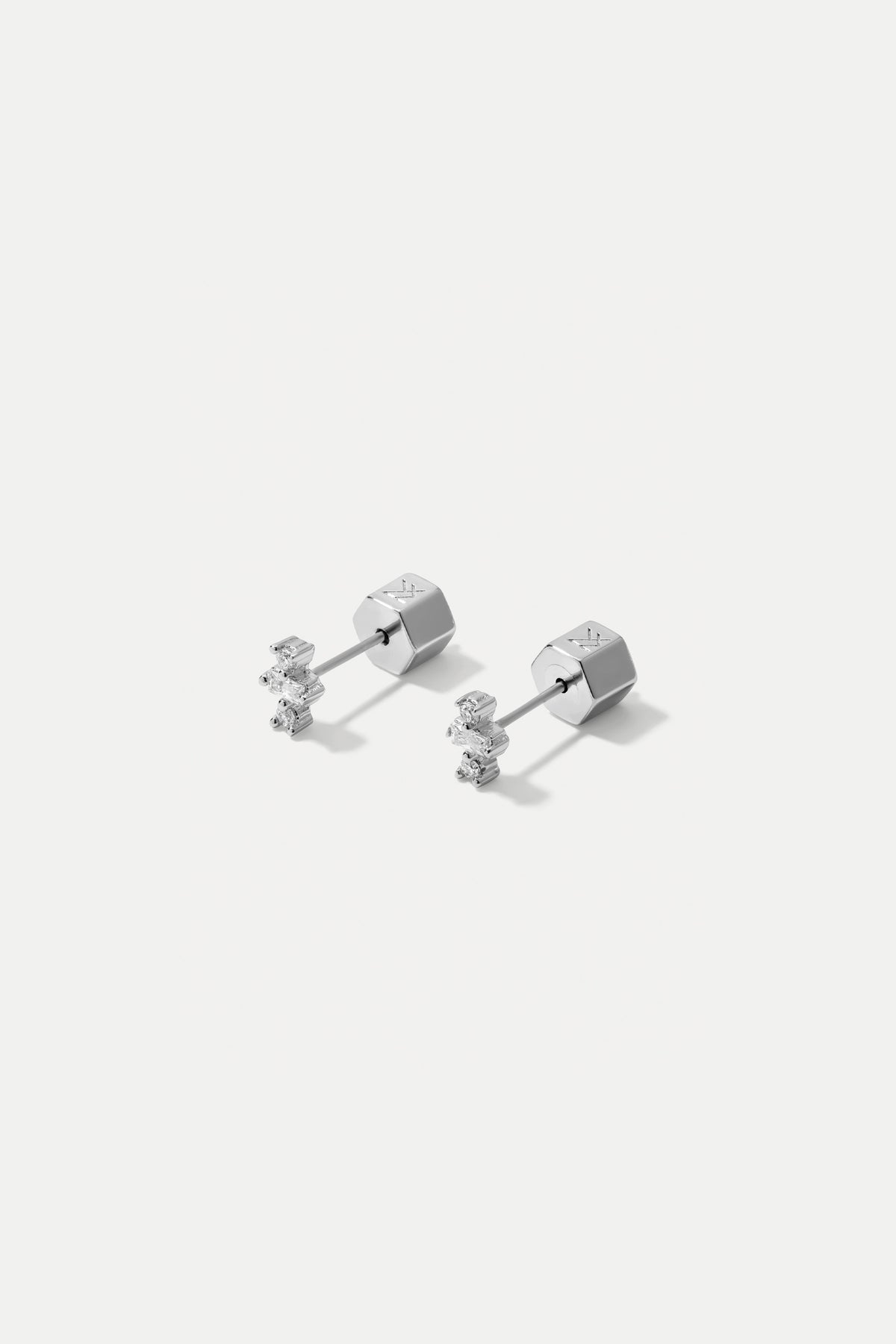 Pair of silver Clara stud earrings featuring baguette and round CZ stones on a white background.