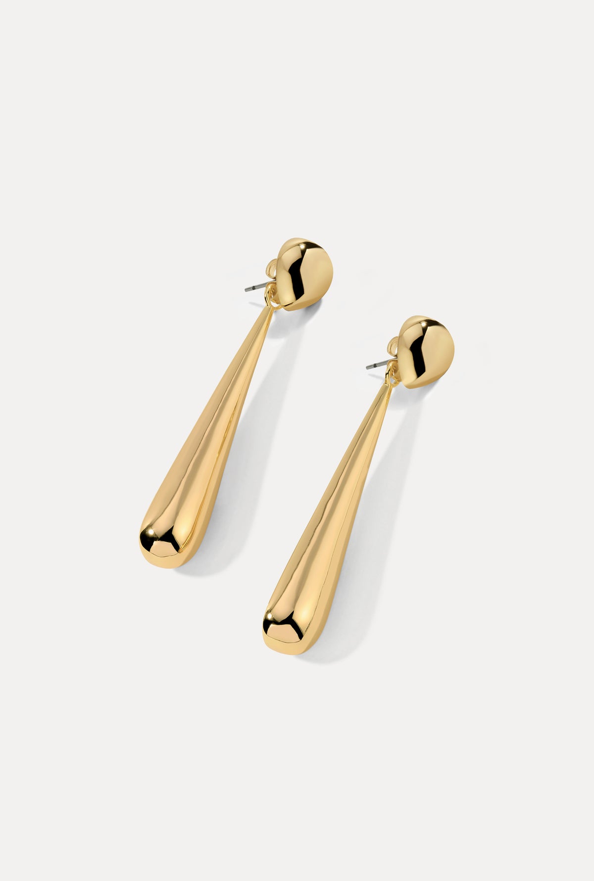 Gold teardrop Claudette earrings with fluid drop design on a white background.