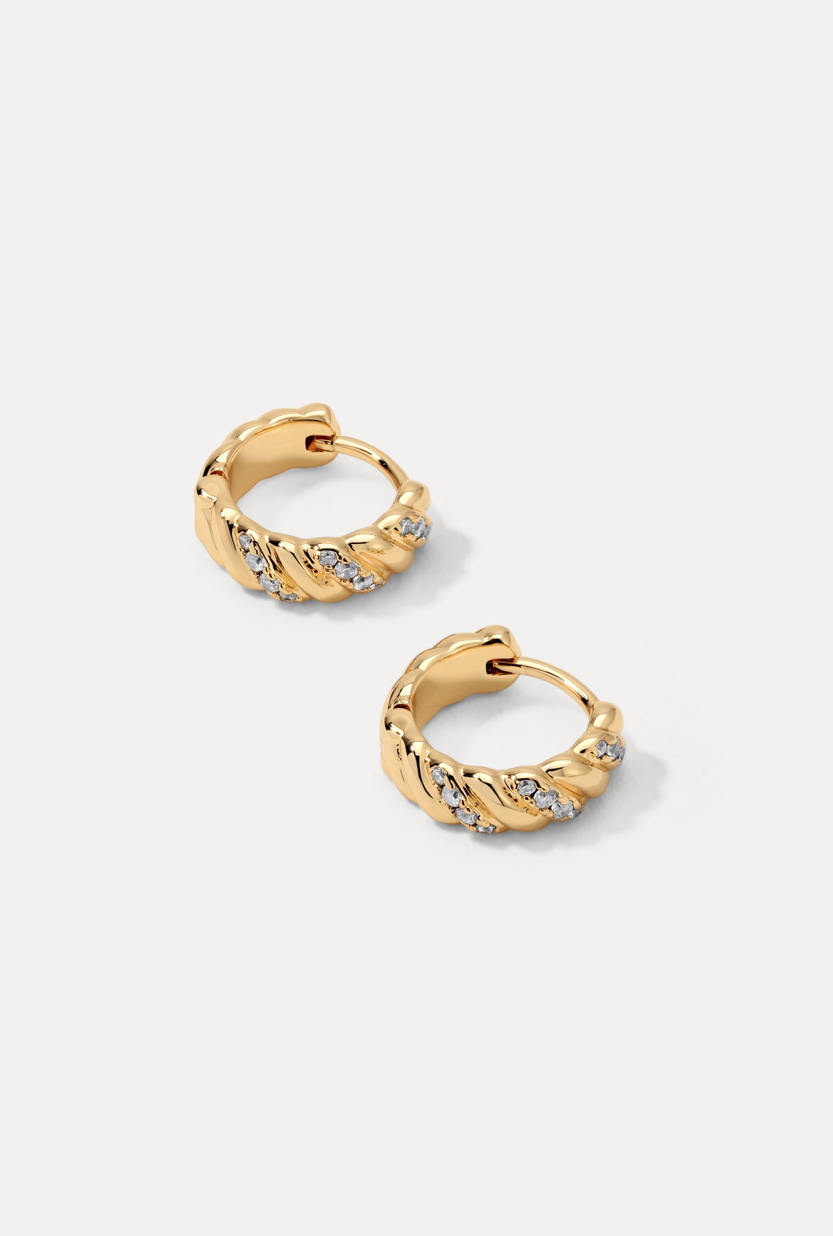 Gold Dahlia huggie hoop earrings with sculpted curves and CZ accents on a plain white background.