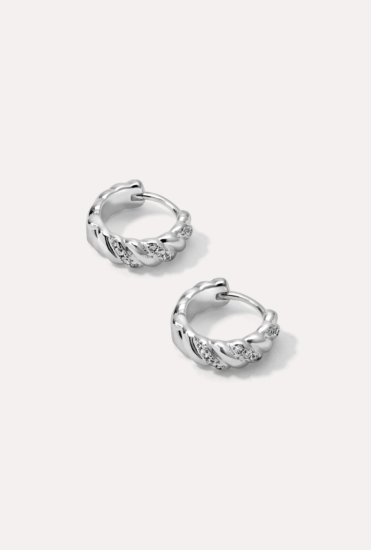 Silver Dahlia huggie hoop earrings with sculpted curves and CZ accents on a plain white background.