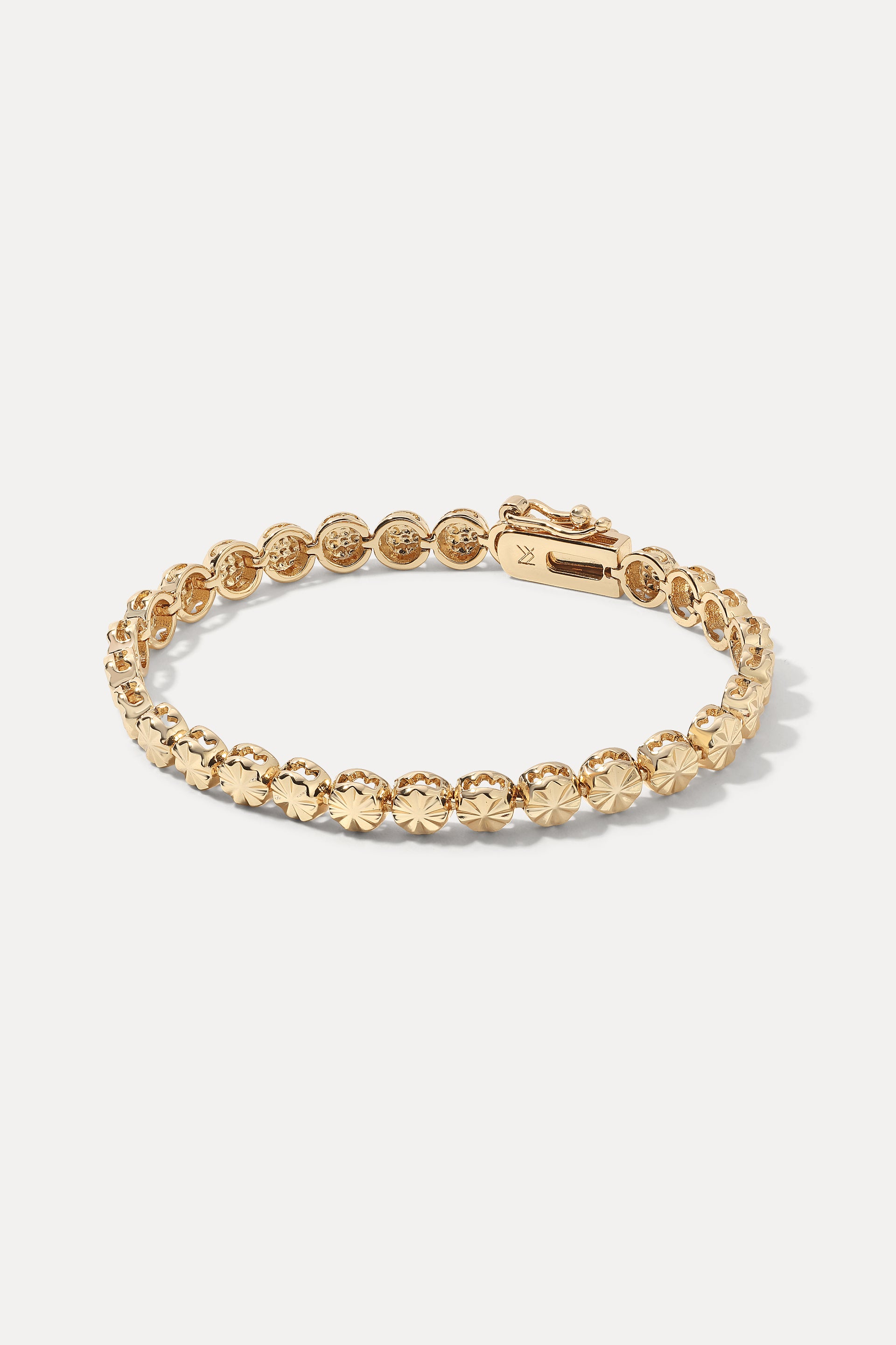 Gold Essie Bracelet displayed flat on a white background, highlighting its starburst-engraved medallions.
