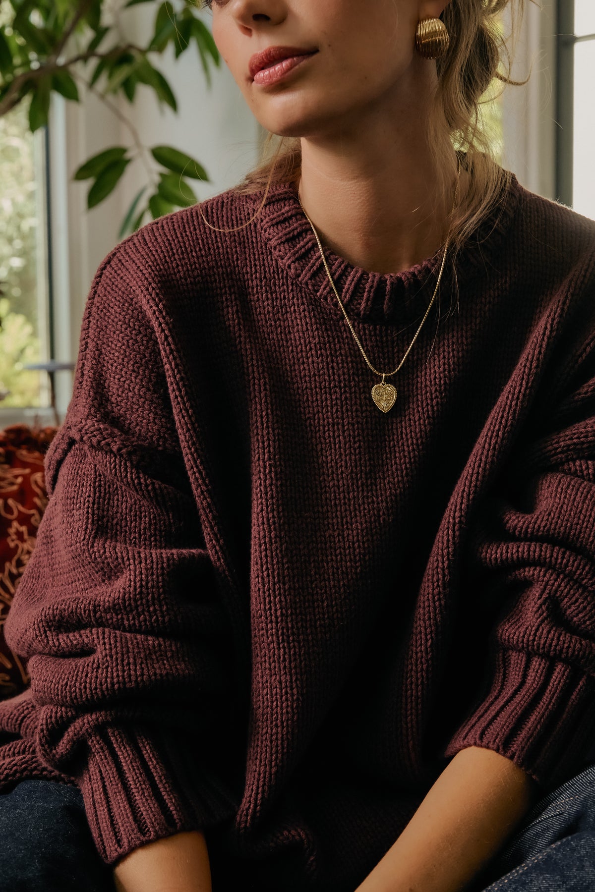 Model wearing gold Mina chain with Forever Charm and Florence earrings, styled with a burgundy sweater.