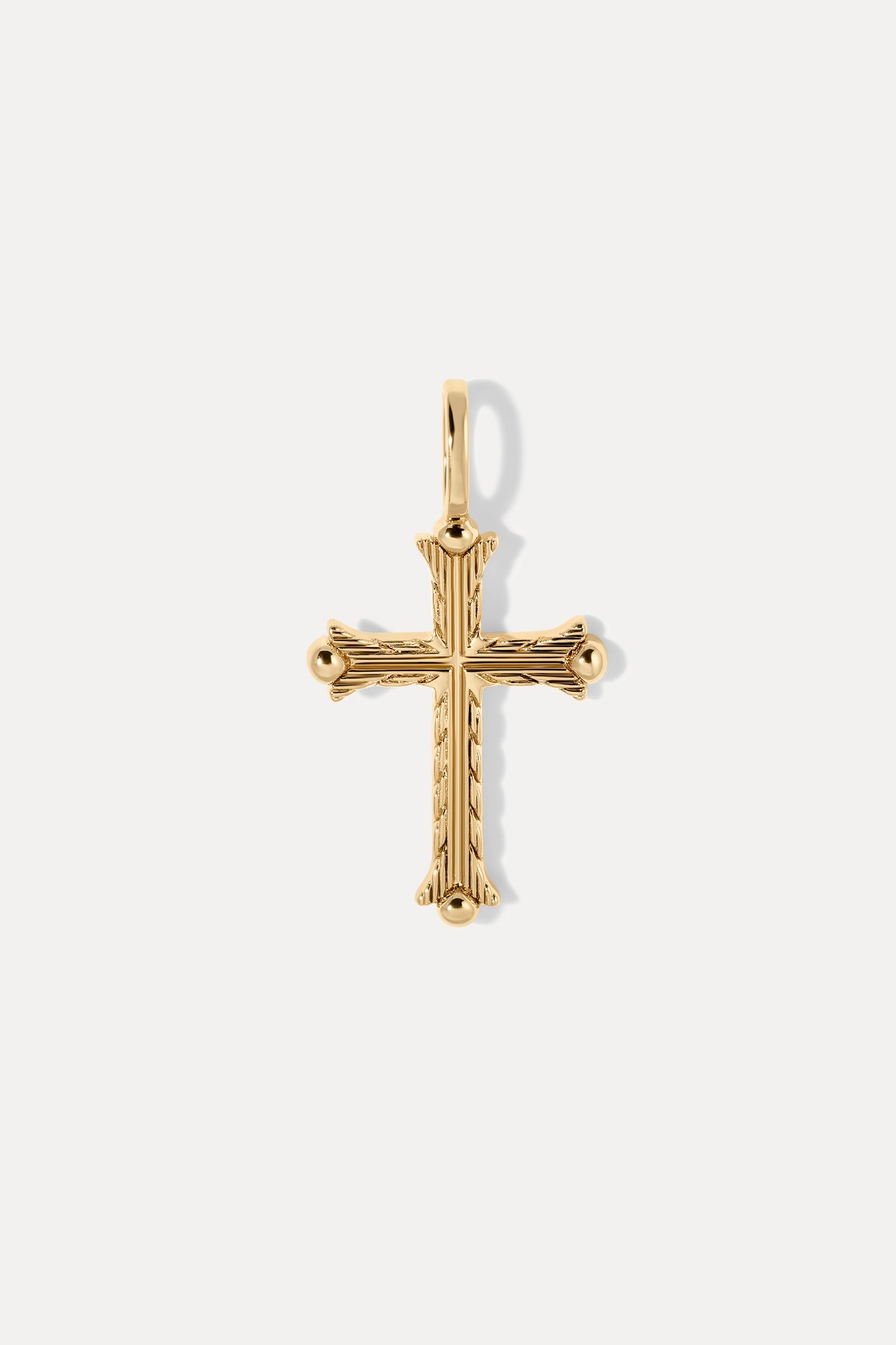 Gold Faith Charm with intricate linear engravings and textured cross details on a white background.