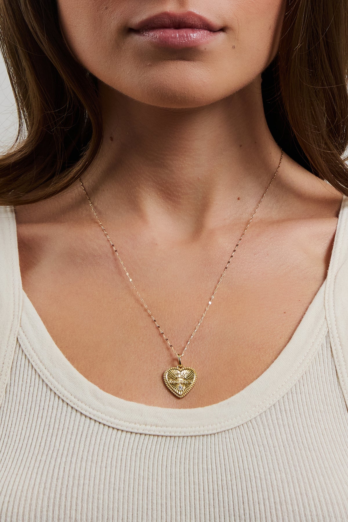 Model wearing gold Forever charm on the gold filled Nora chain, styled with a cream ribbed tank